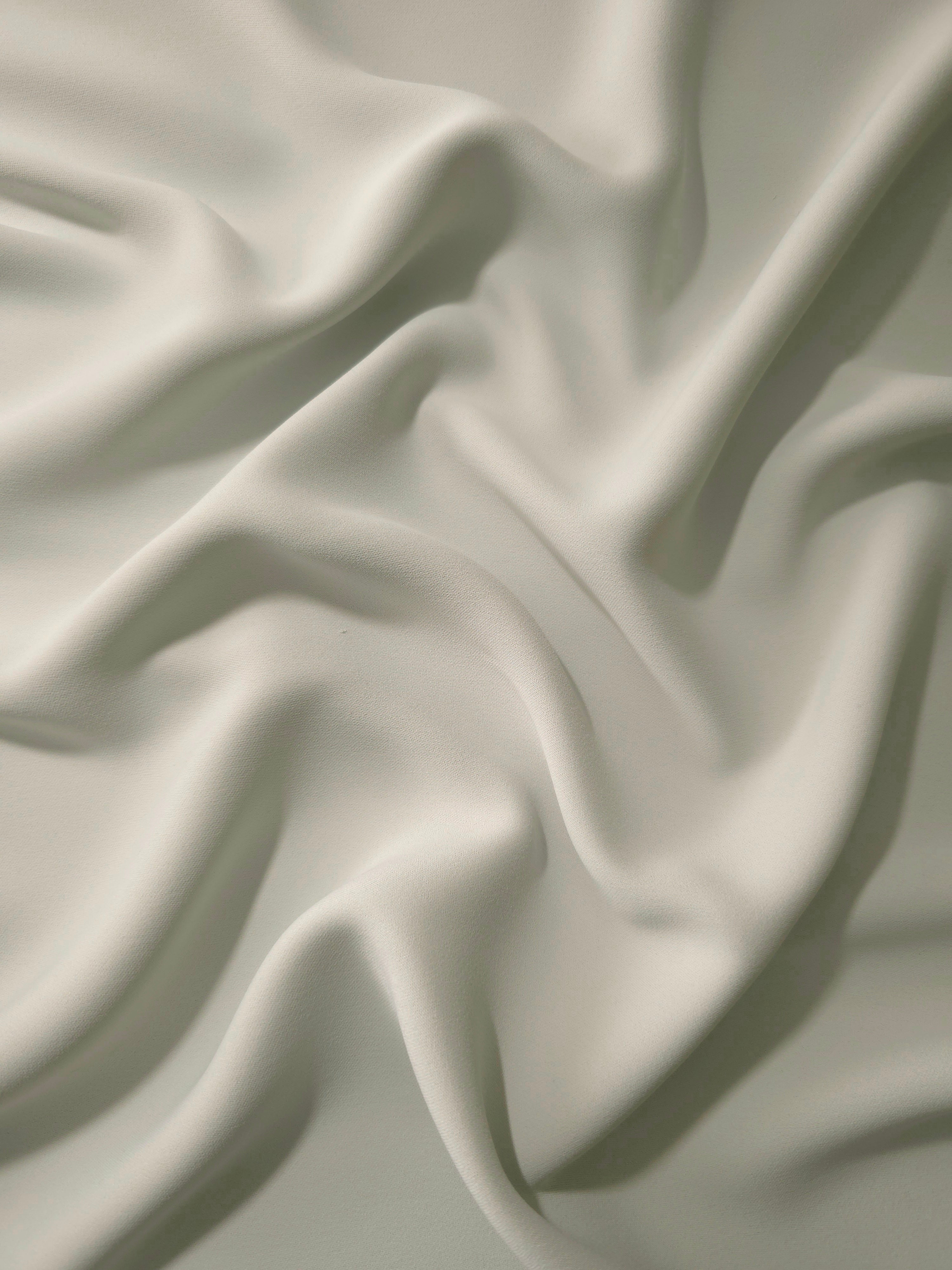 Draped Frosted Ivory Silky Italian Crepe showing an elegant fall through draped folds, ideal for abayas, tunics and elegant shirt dresses.
