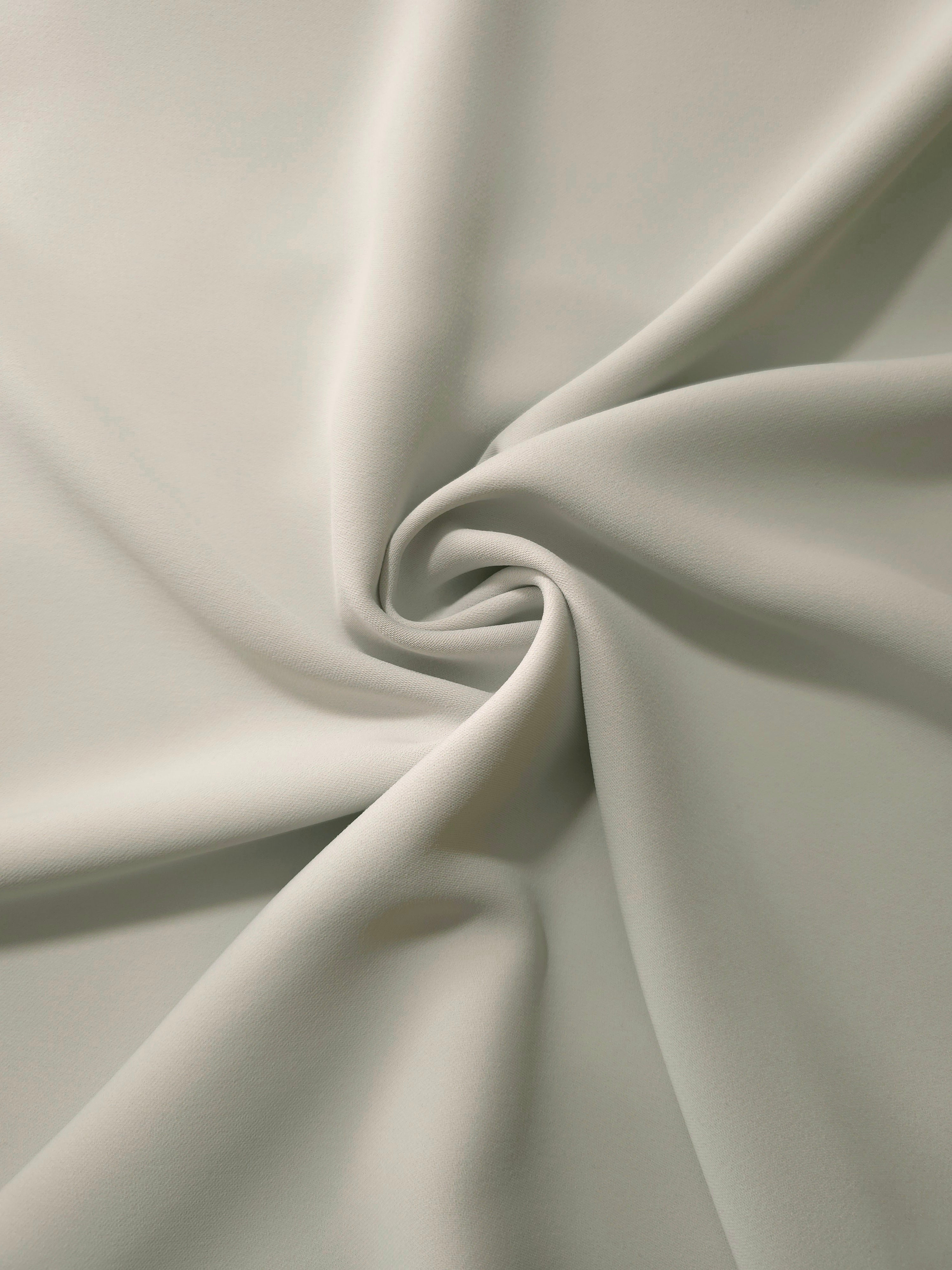 Swirled Frosted Ivory Silky Italian Crepe showing flowing movement in a swirl drape, versatile for evening dresses, flowing skirts and occasionwear tops.