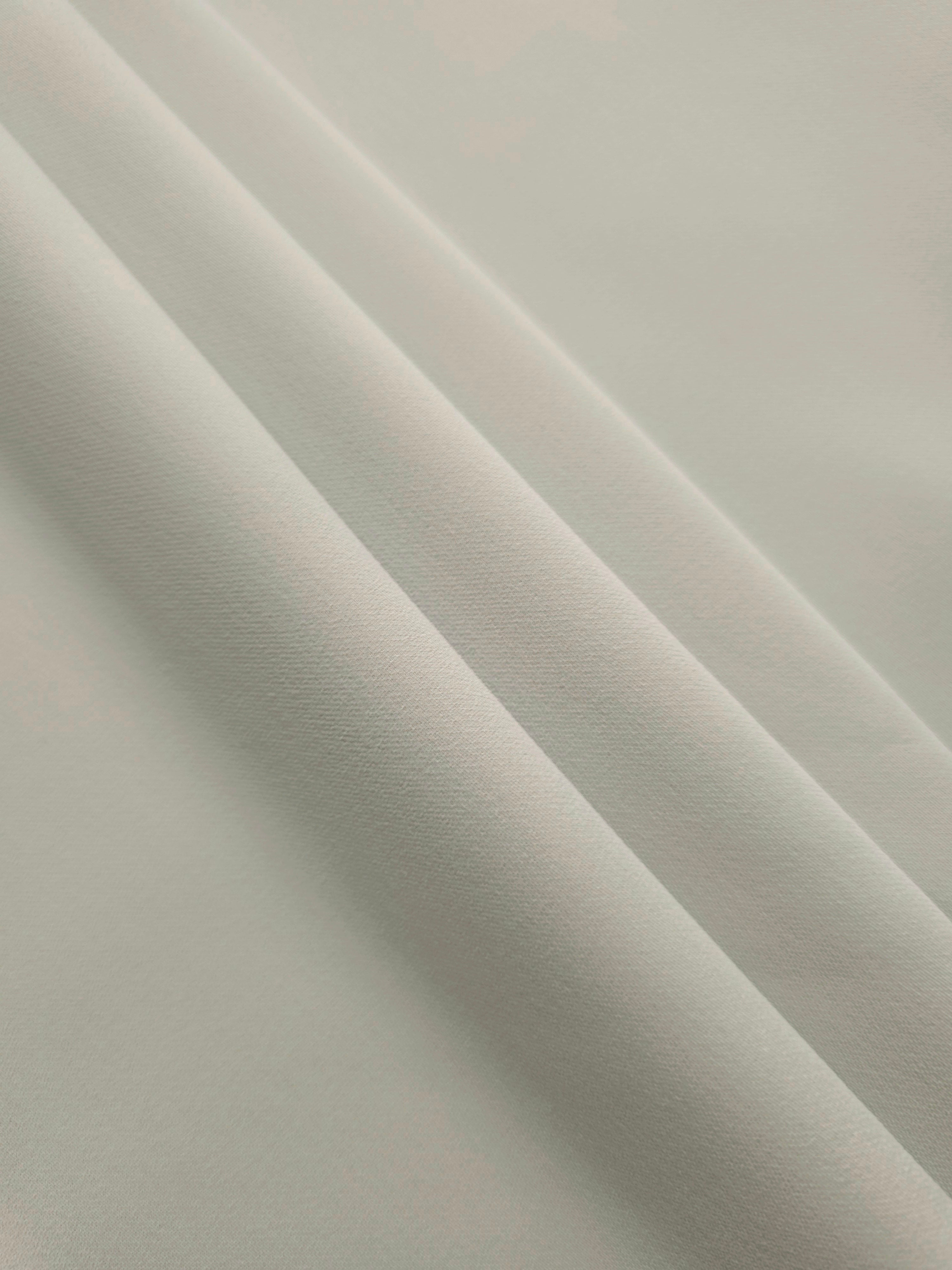 Layered Frosted Ivory Silky Italian Crepe showing soft structure in layered folds, suitable for maxi dresses, modest sets and lightweight tailoring.