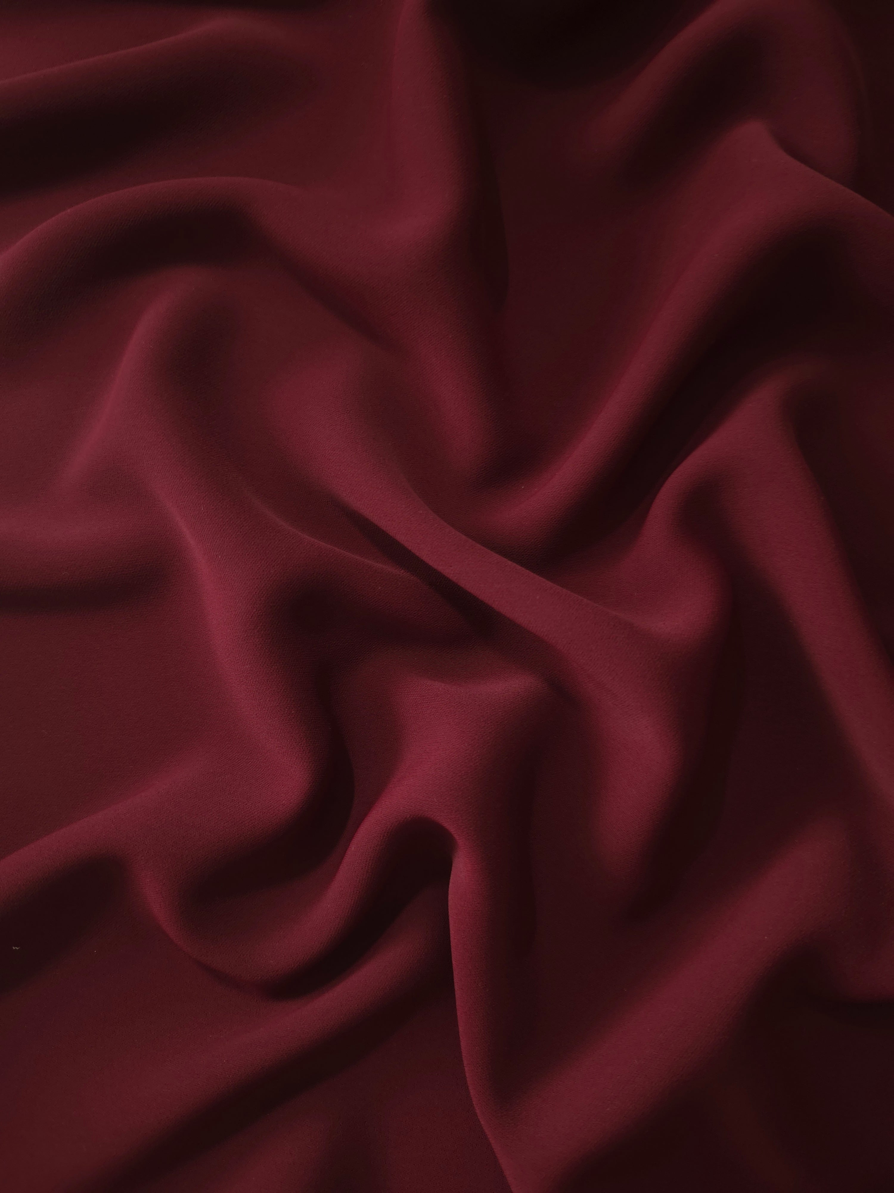 Draped Garnet Wine Silky Italian Crepe showing an elegant fall through draped folds, ideal for draped dresses, elegant tops and modest fashion.