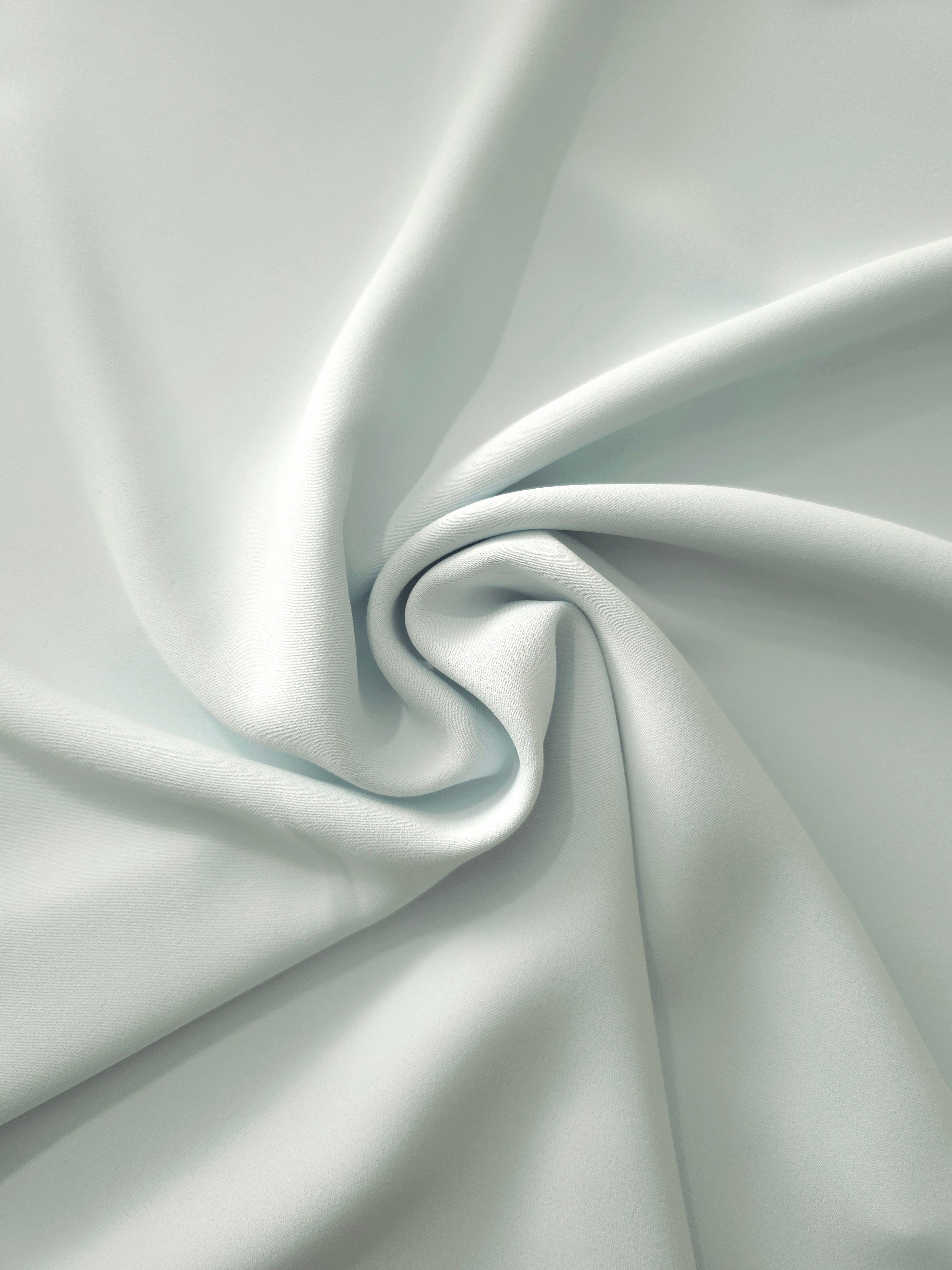 Swirled Glacial Mint Silky Italian Crepe showing flowing movement in a swirl drape, versatile for bridesmaid dresses, blouses and refined separates.