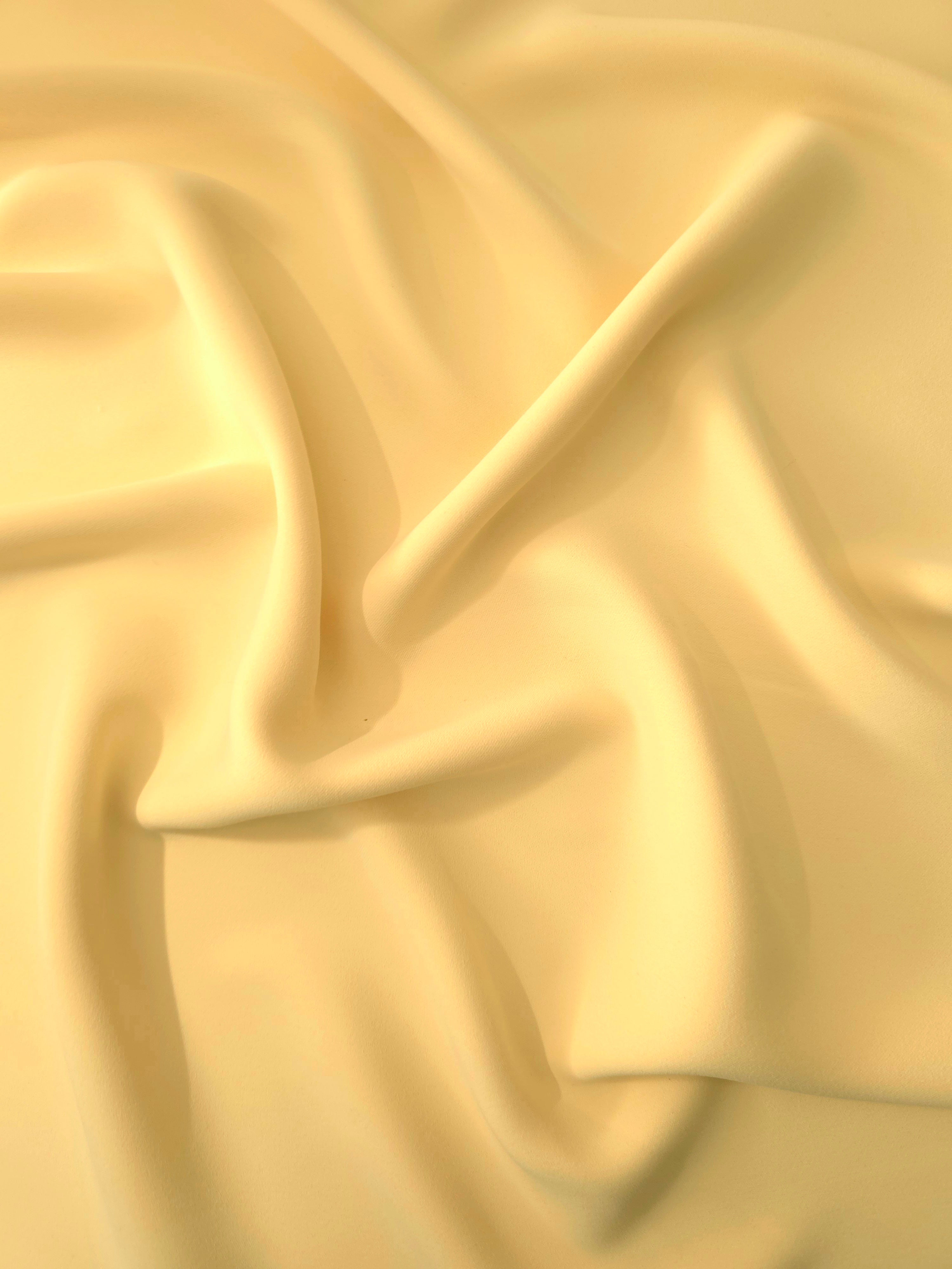 Draped Honey Marigold Silky Italian Crepe showing an elegant fall through draped folds, ideal for wrap dresses, wide-leg trousers and dressy co-ords.