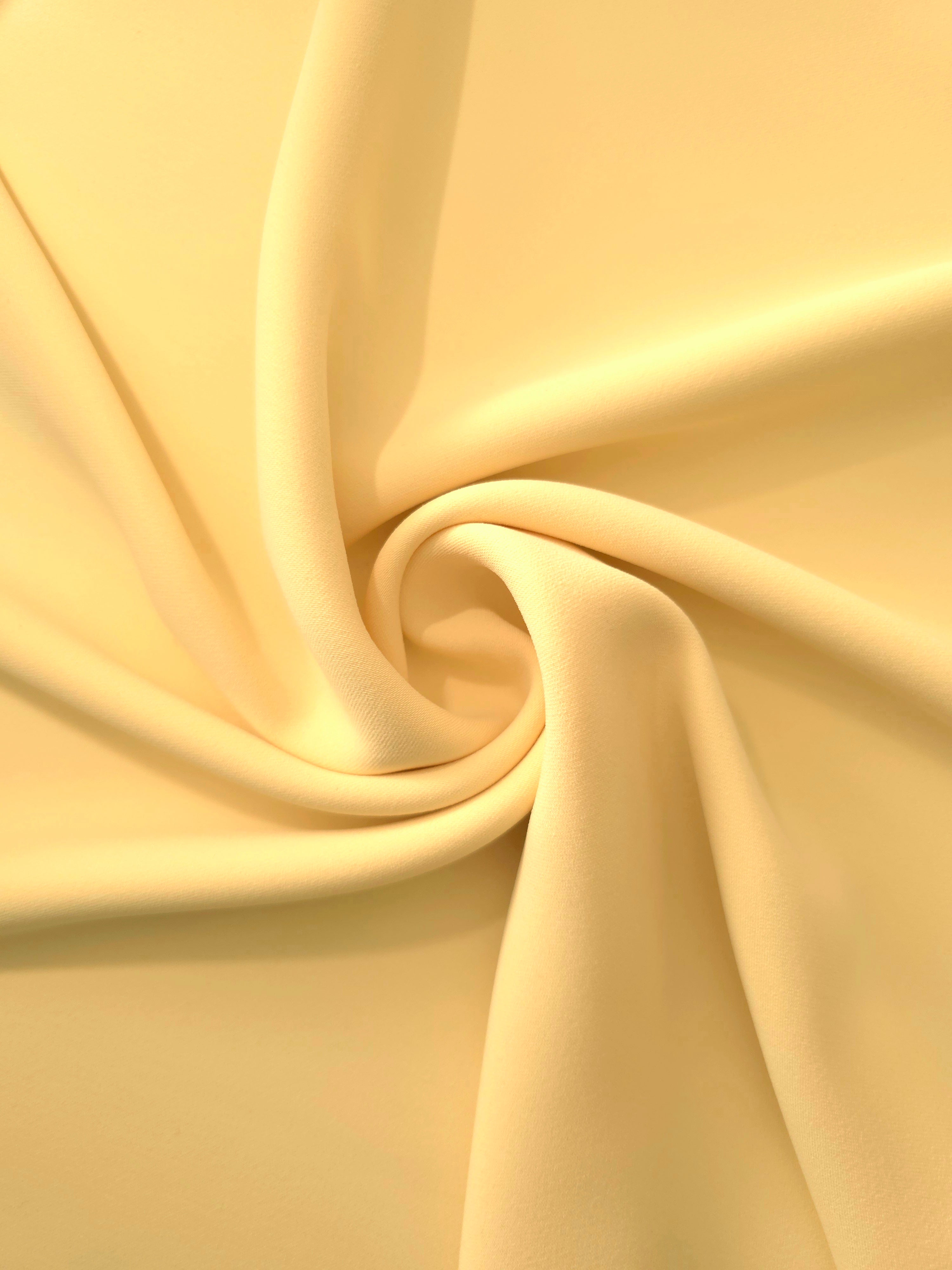 Swirled Honey Marigold Silky Italian Crepe showing flowing movement in a swirl drape, versatile for formal gowns, abayas and special-occasion skirts.