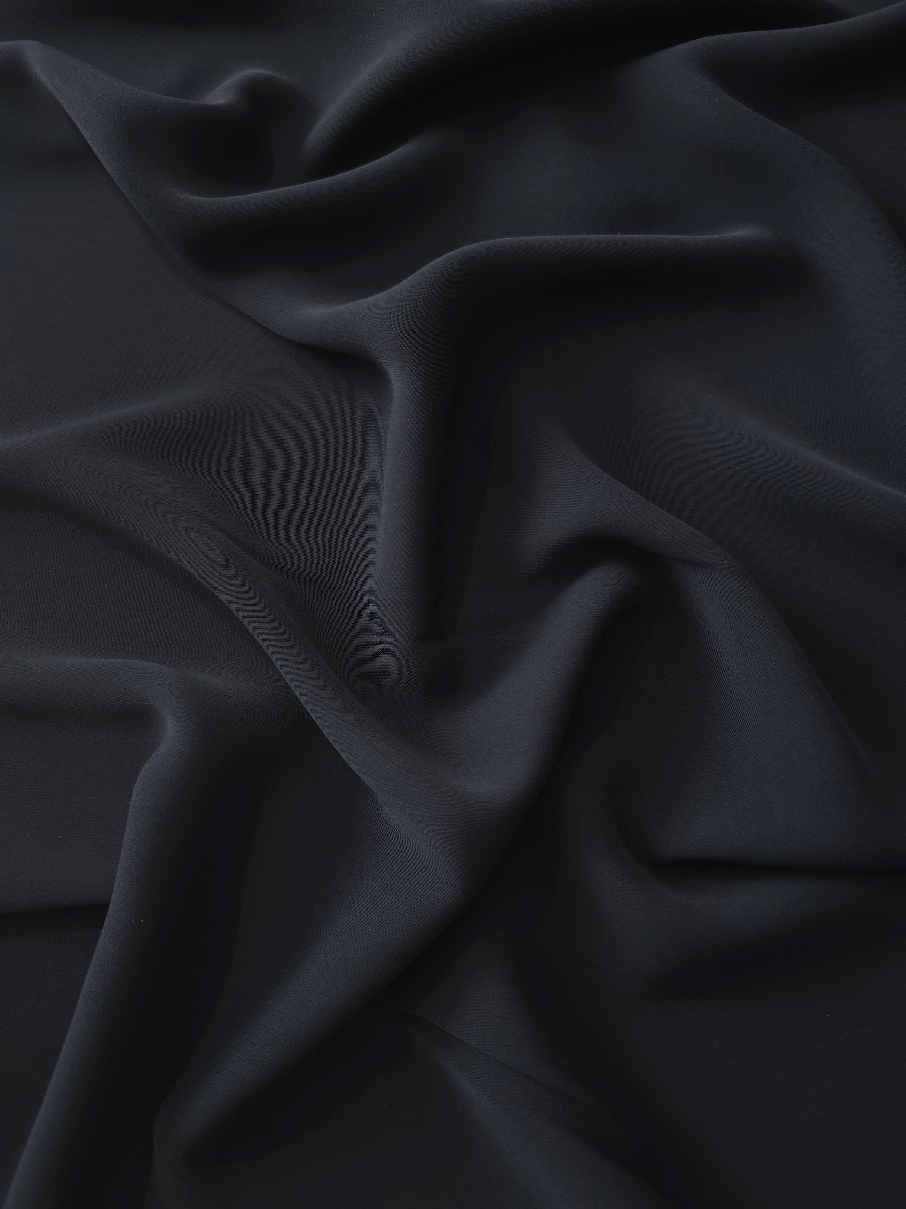 Draped Ink Blue Black Silky Italian Crepe showing an elegant fall through draped folds, ideal for maxi dresses, modest sets and lightweight tailoring.