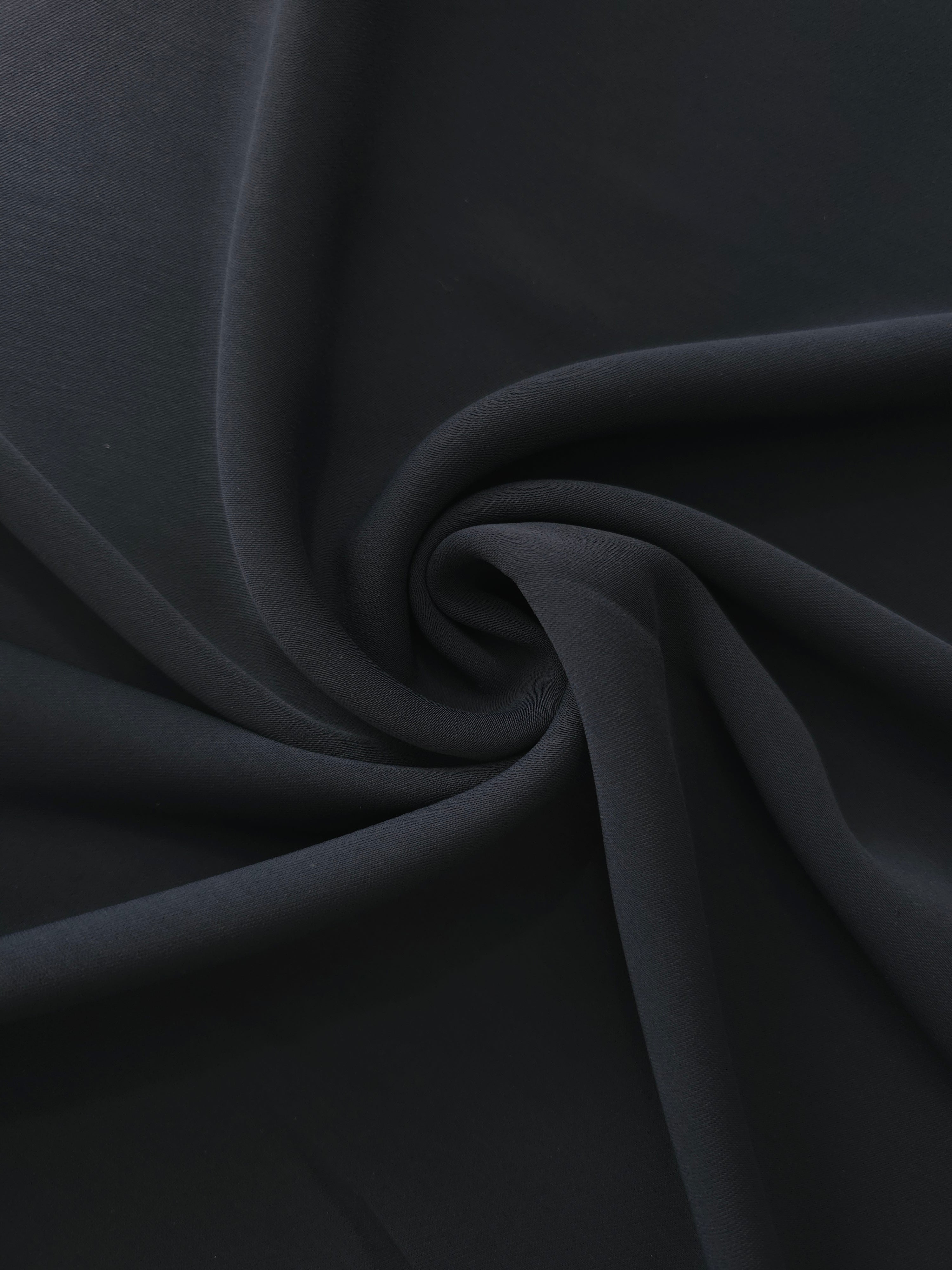 Swirled Ink Blue Black Silky Italian Crepe showing flowing movement in a swirl drape, versatile for bridesmaid dresses, blouses and refined separates.