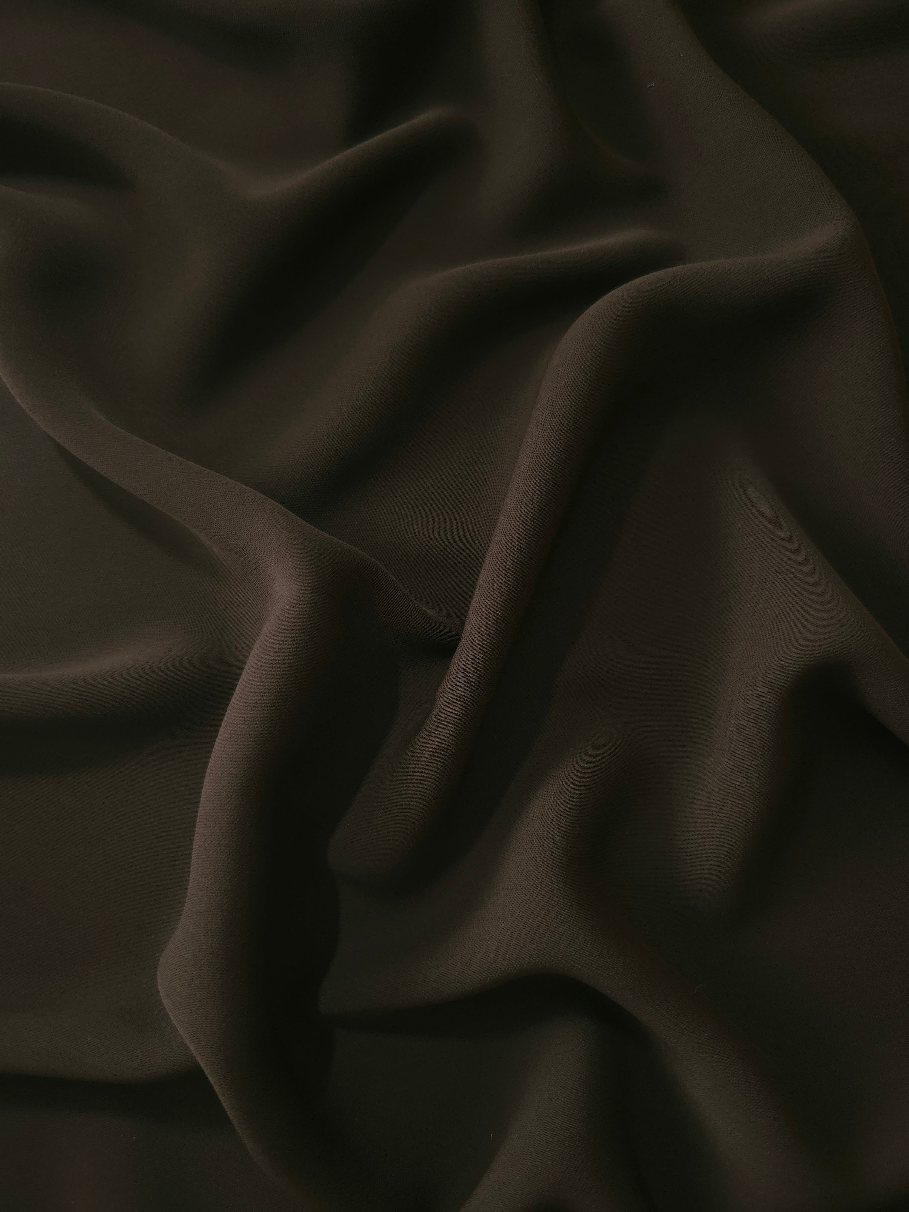 Draped Ink Olive Black Silky Italian Crepe showing an elegant fall through draped folds, ideal for office blouses, tailored dresses and soft jackets.