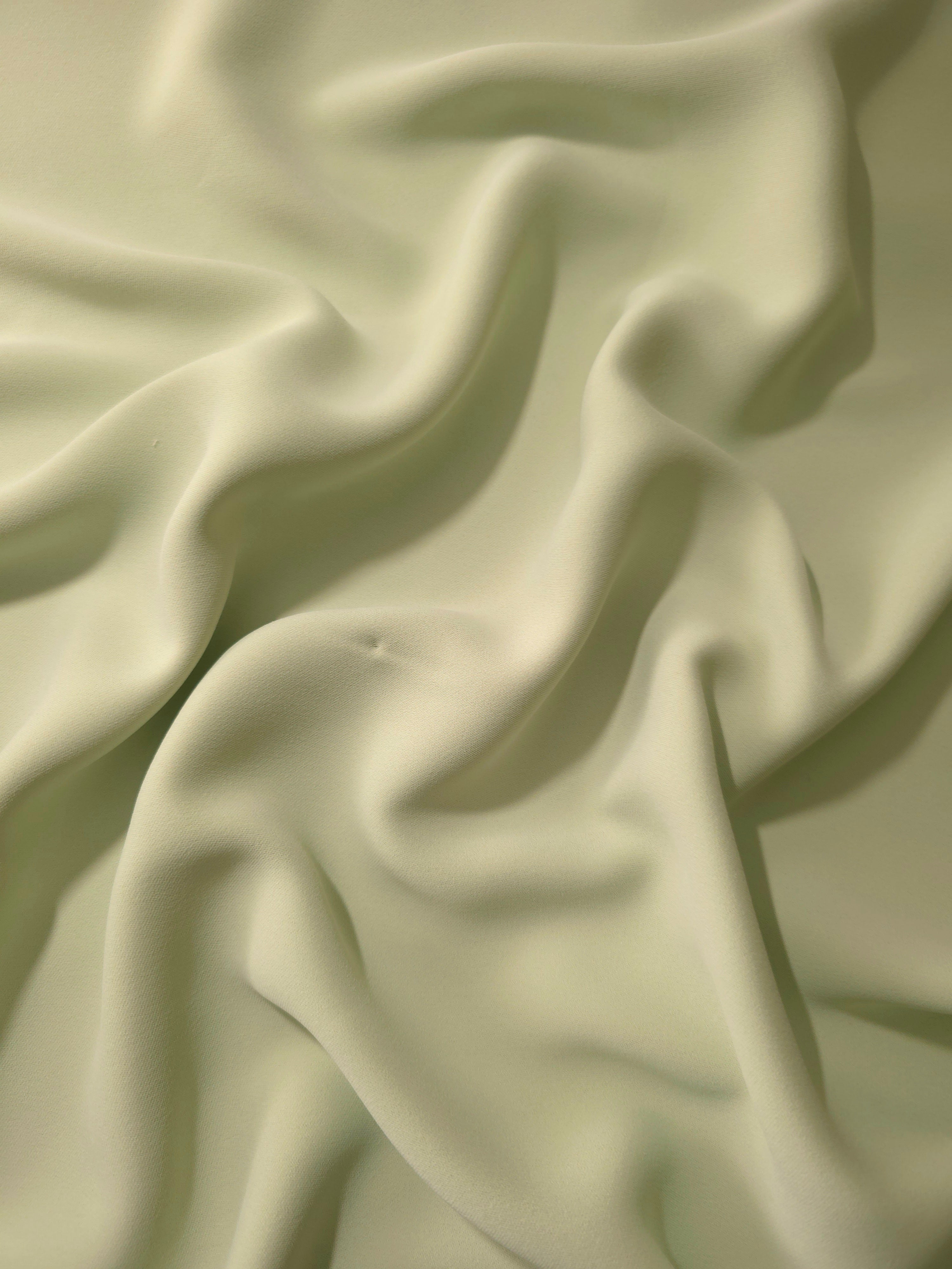 Draped Linden Cream Silky Italian Crepe showing an elegant fall through draped folds, ideal for wrap dresses, wide-leg trousers and dressy co-ords.