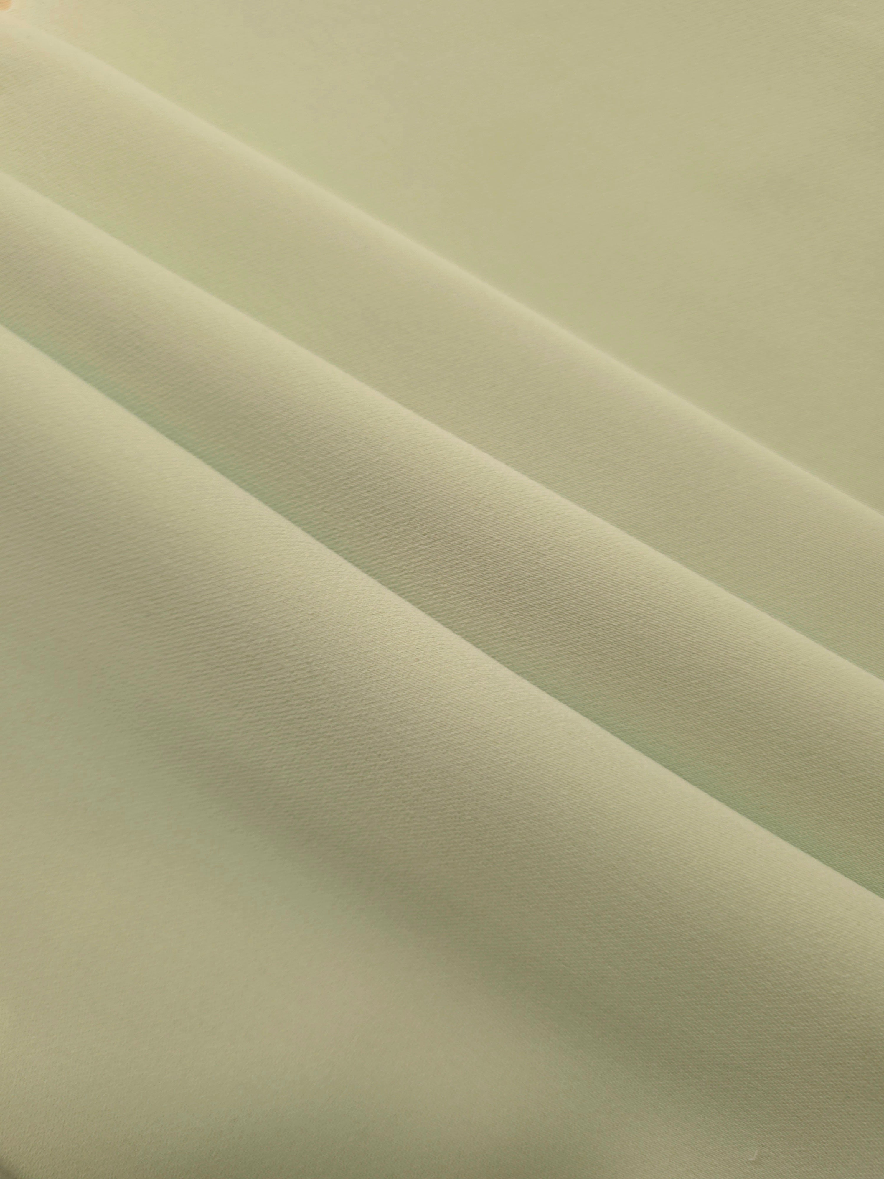Swirled Linden Cream Silky Italian Crepe showing flowing movement in a swirl drape, versatile for formal gowns, abayas and special-occasion skirts.