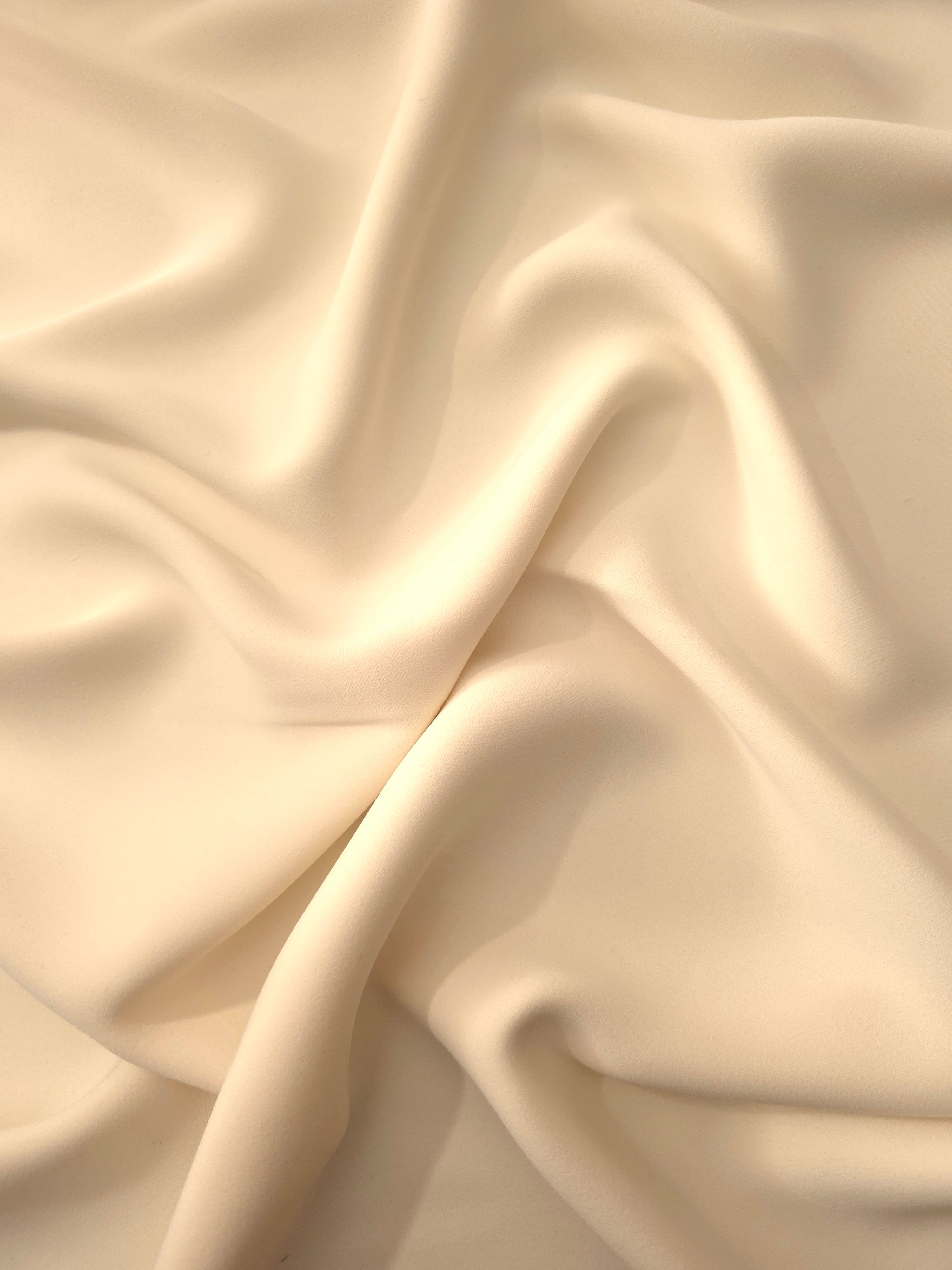 Draped Oat Almond Cream Silky Italian Crepe showing an elegant fall through draped folds, ideal for draped dresses, elegant tops and modest fashion.