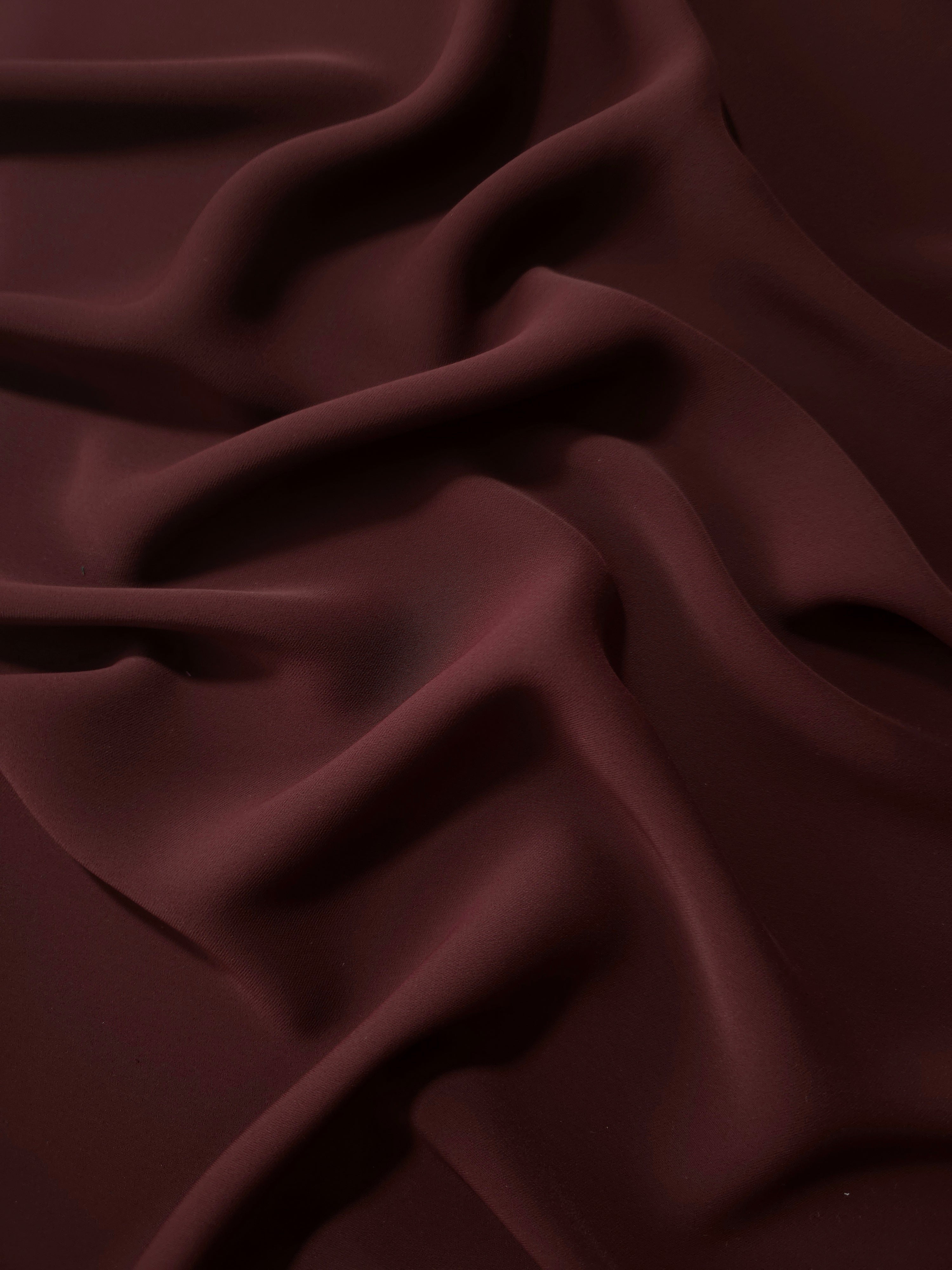 Draped Oxblood Cocoa Silky Italian Crepe showing an elegant fall through draped folds, ideal for abayas, tunics and elegant shirt dresses.