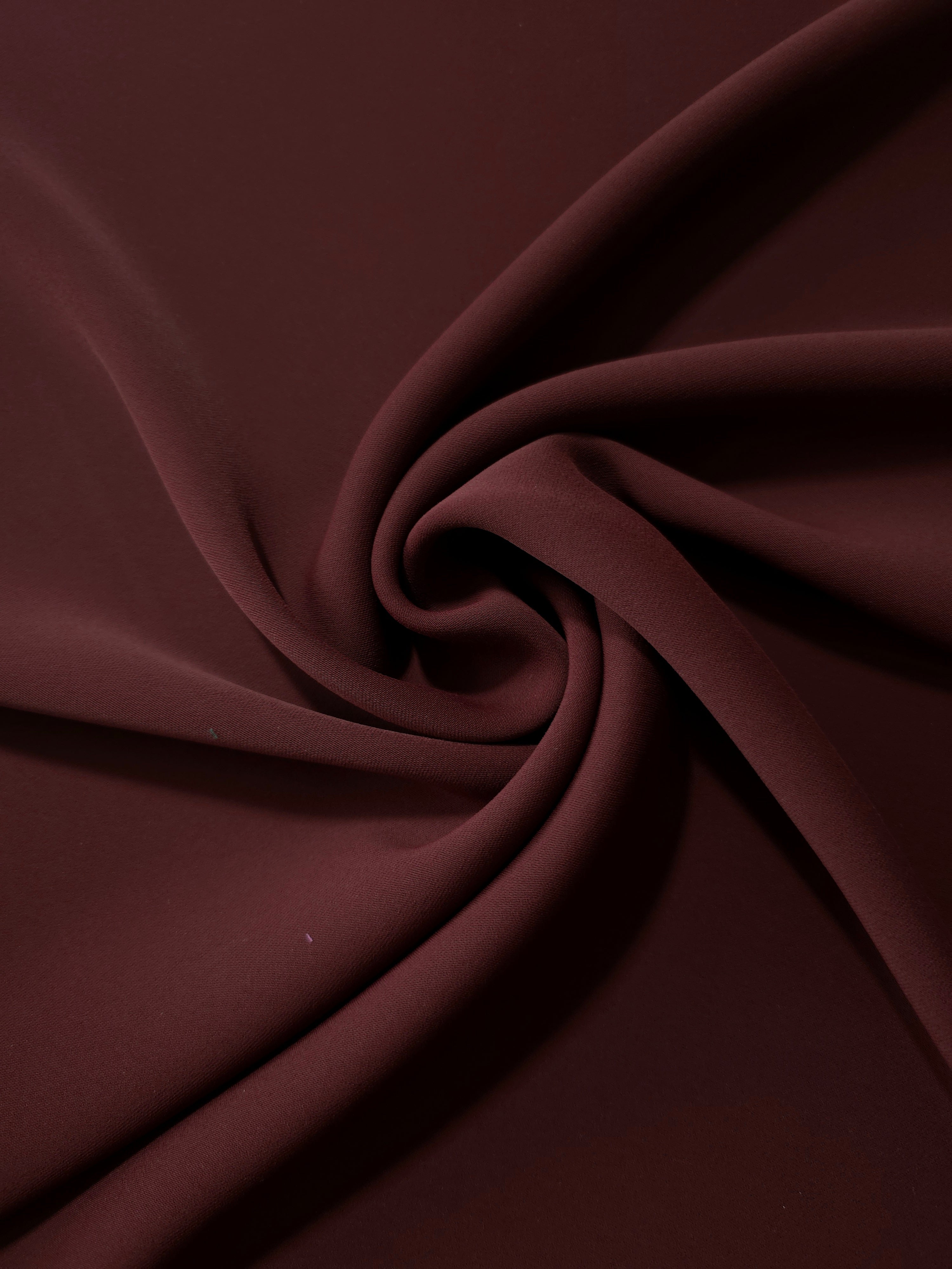 Swirled Oxblood Cocoa Silky Italian Crepe showing flowing movement in a swirl drape, versatile for evening dresses, flowing skirts and occasionwear tops.