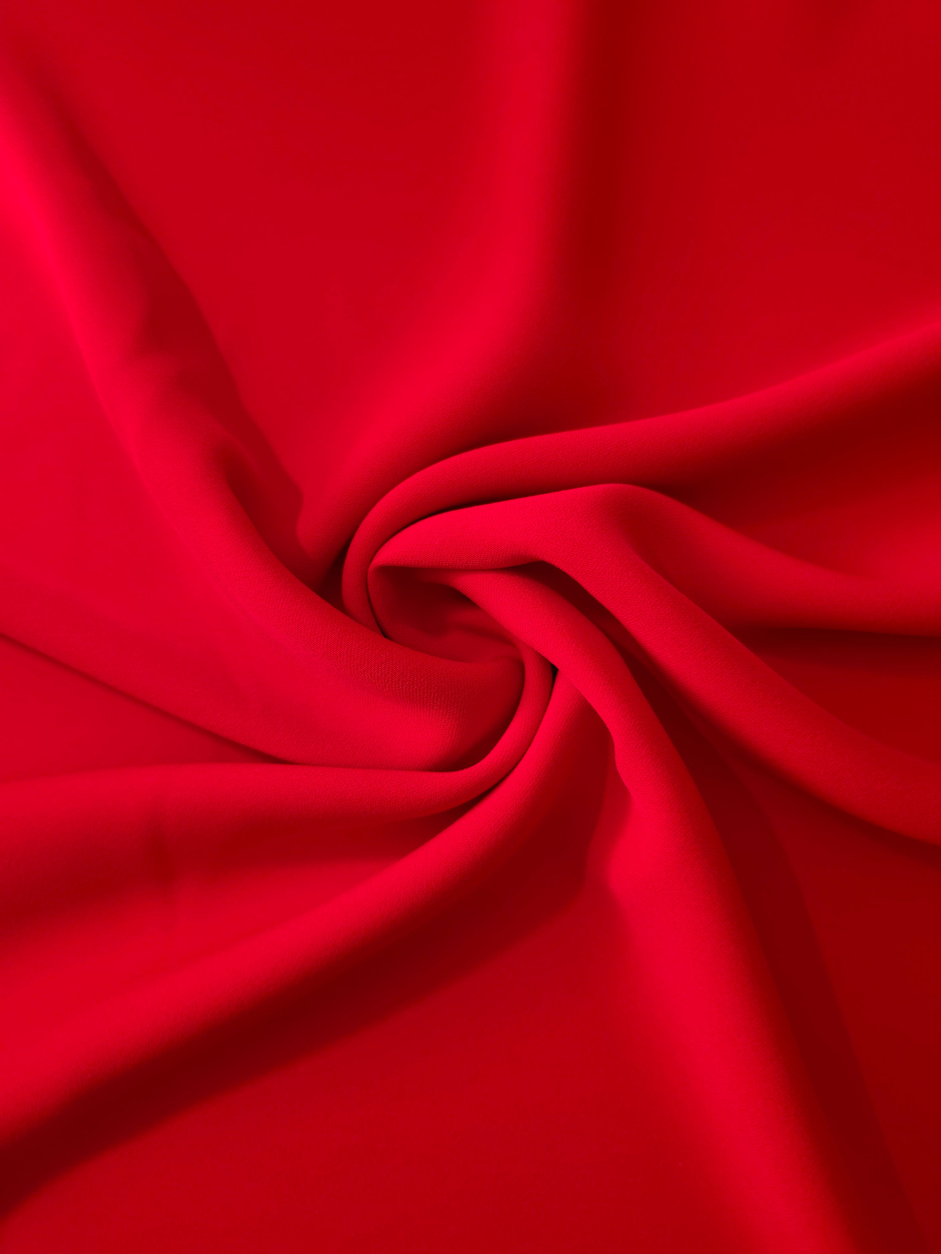 Swirled Poppy Scarlet Silky Italian Crepe showing flowing movement in a swirl drape, versatile for formal gowns, abayas and special-occasion skirts.