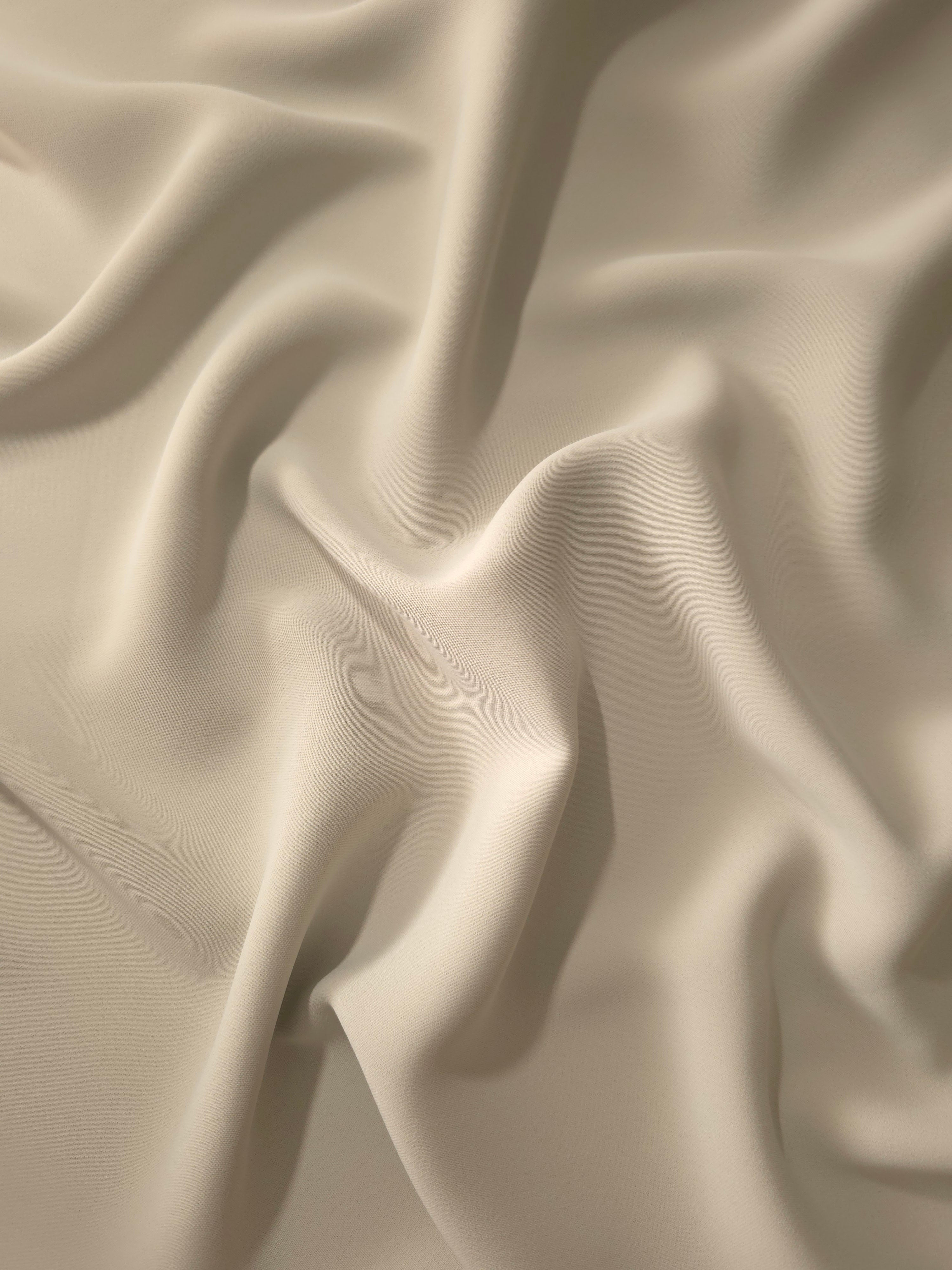 Draped Porcelain Greige Silky Italian Crepe showing an elegant fall through draped folds, ideal for draped dresses, elegant tops and modest fashion.