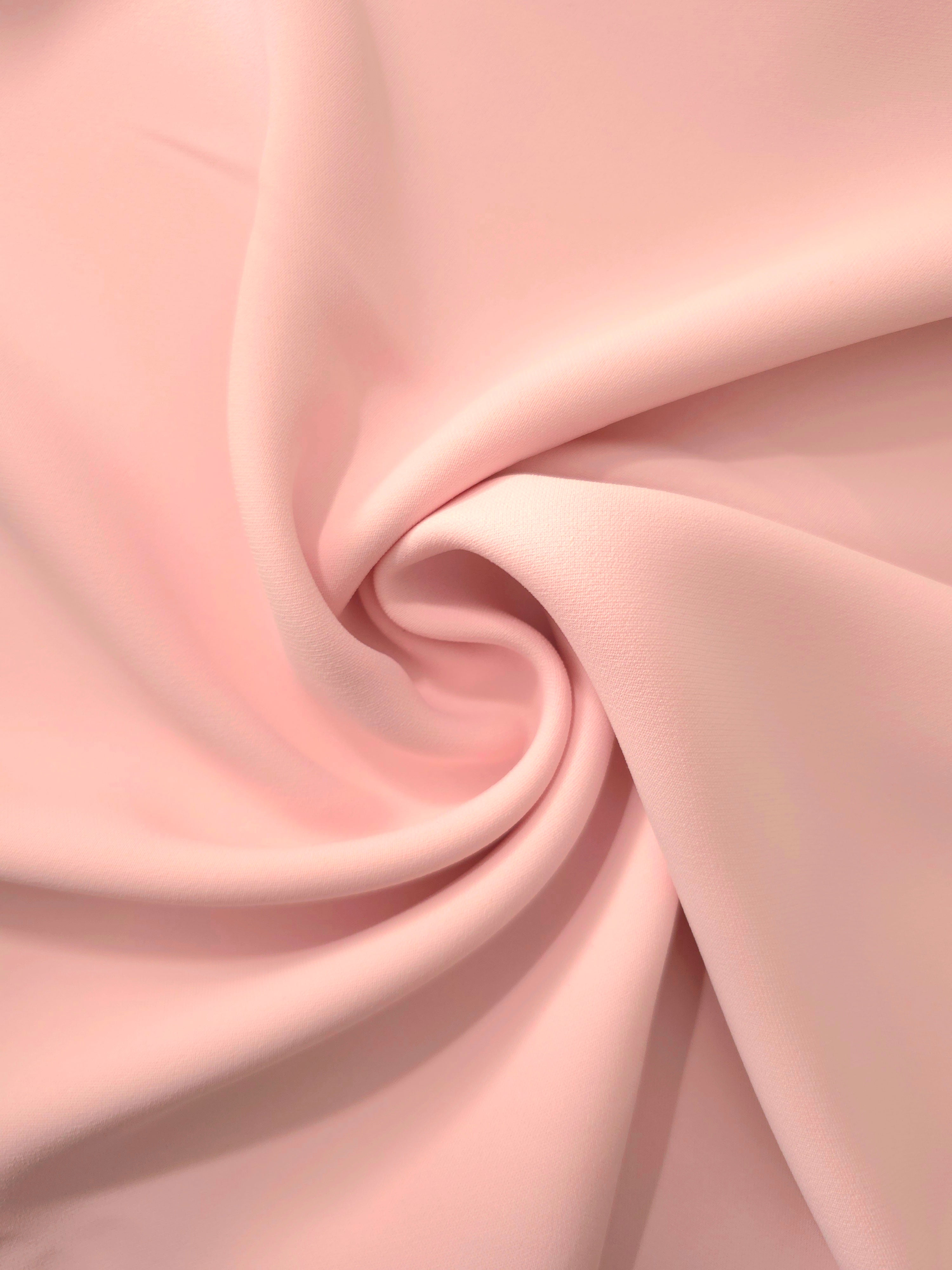 Swirled Rosewater Peach Silky Italian Crepe showing flowing movement in a swirl drape, versatile for bridesmaid dresses, blouses and refined separates.