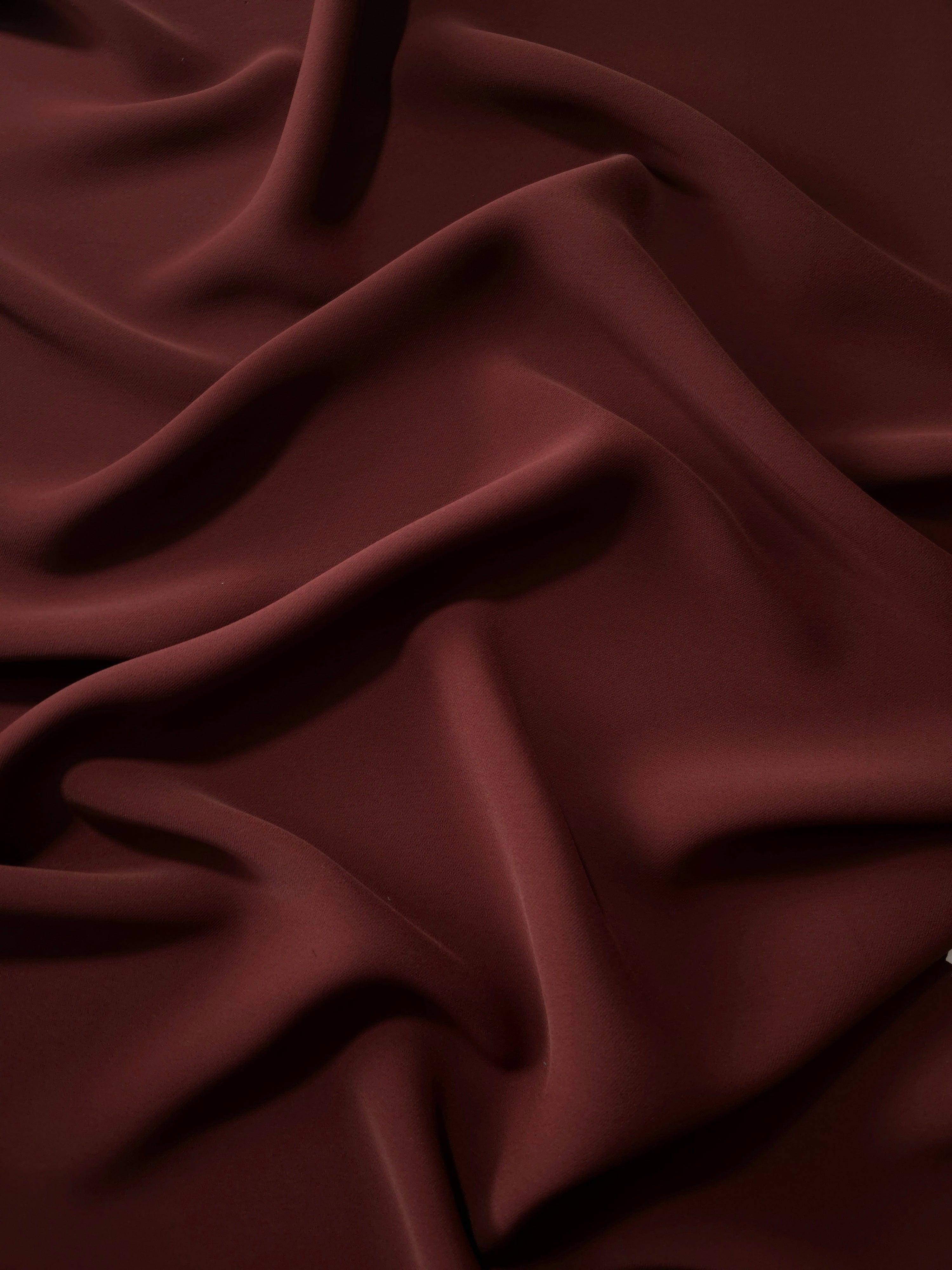 Draped Russet Mahogany Silky Italian Crepe showing an elegant fall through draped folds, ideal for wrap dresses, wide-leg trousers and dressy co-ords.