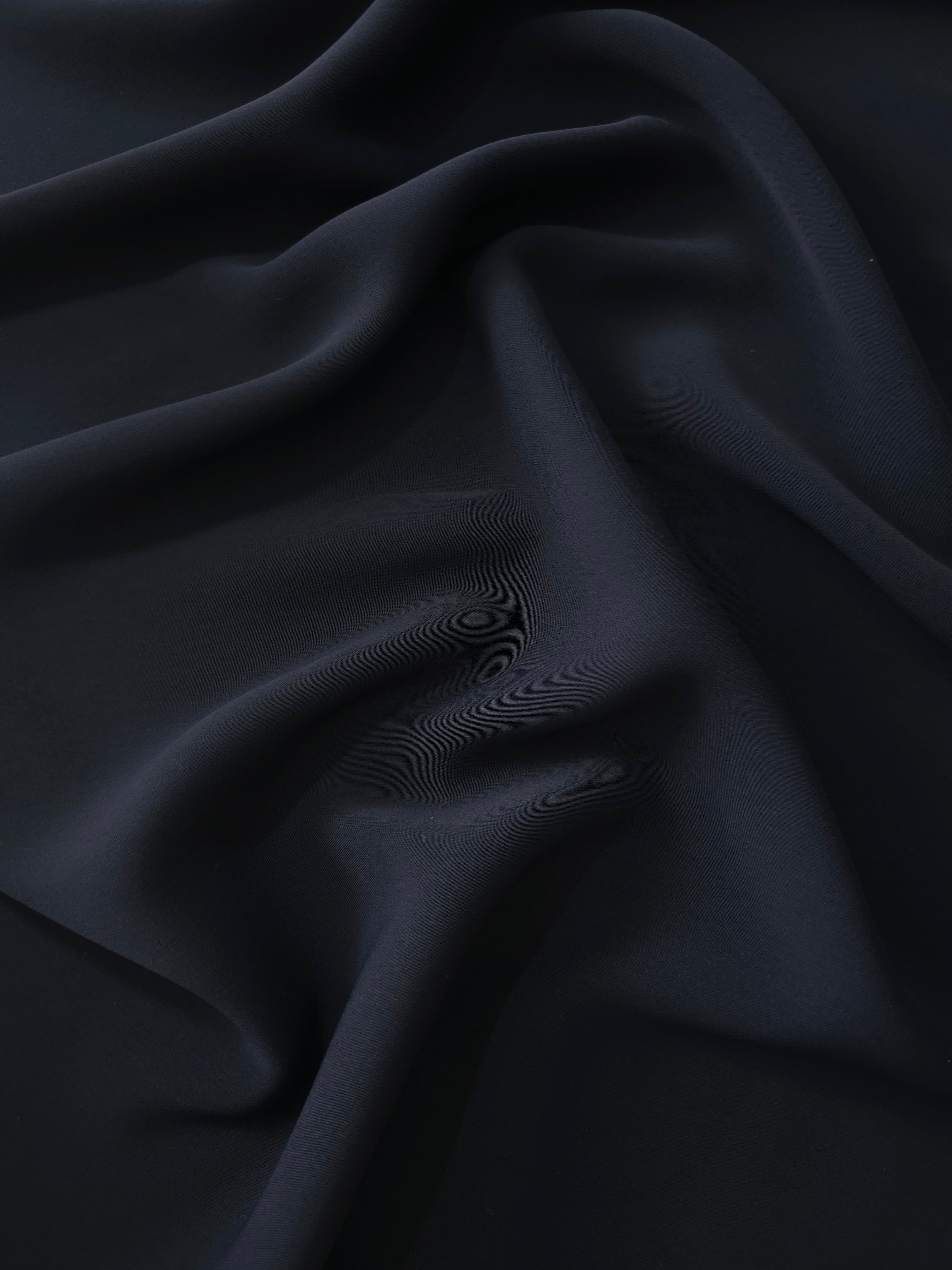 Draped Storm Navy Silky Italian Crepe showing an elegant fall through draped folds, ideal for abayas, tunics and elegant shirt dresses.