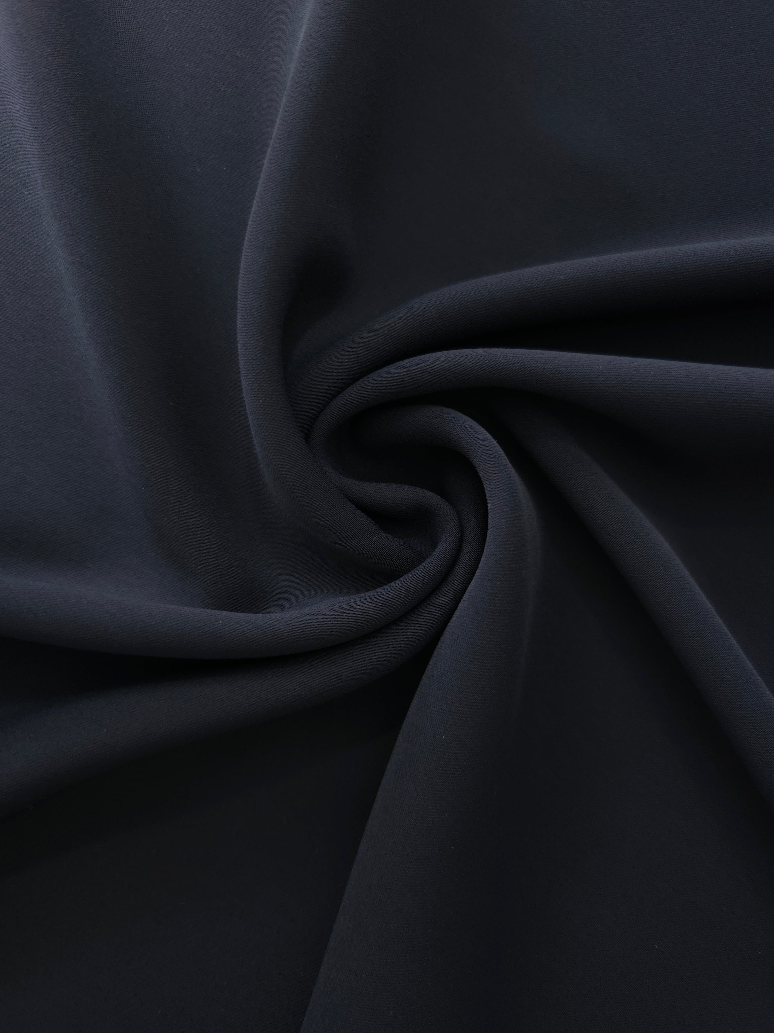 Swirled Storm Navy Silky Italian Crepe showing flowing movement in a swirl drape, versatile for evening dresses, flowing skirts and occasionwear tops.