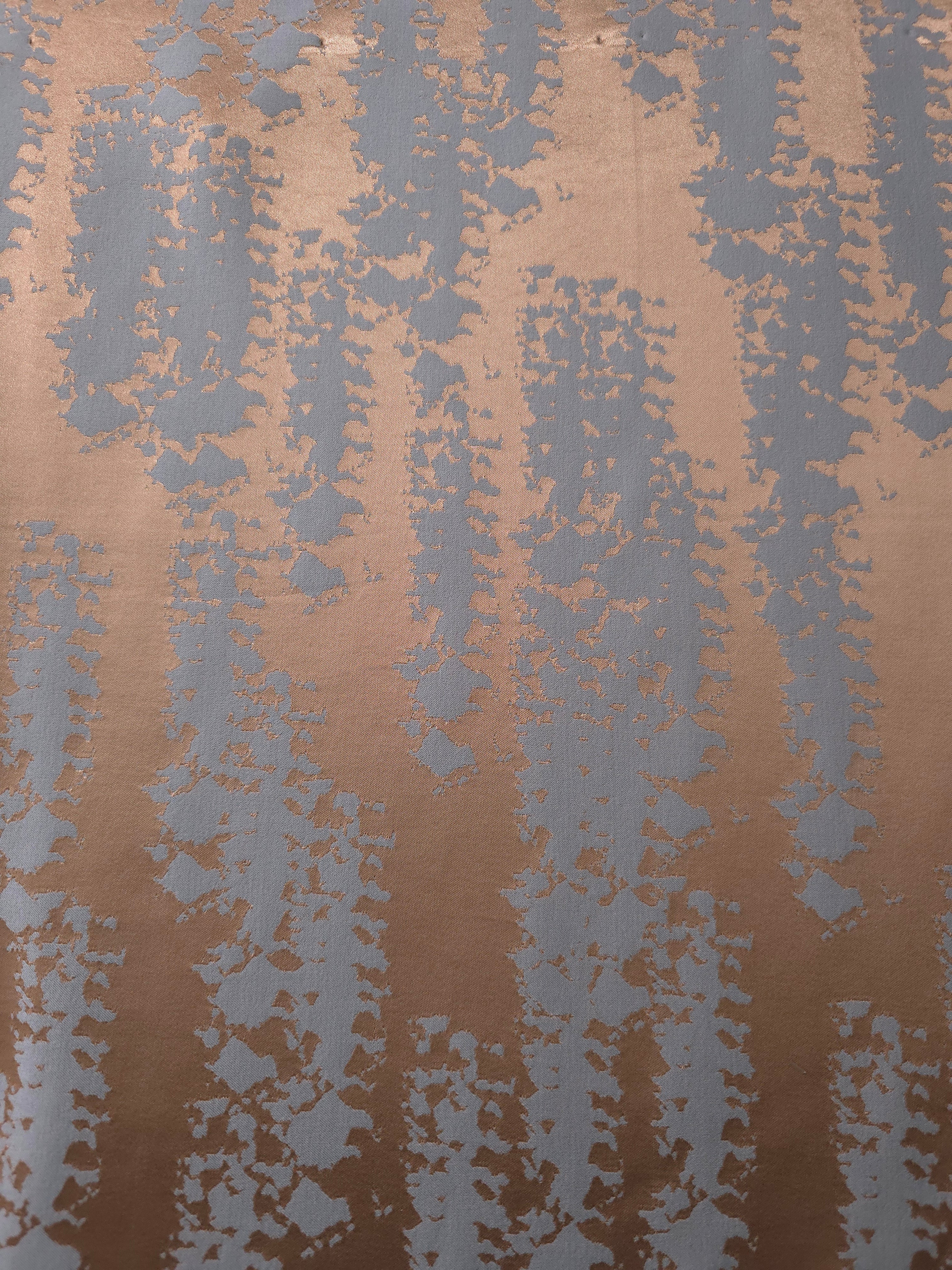 A wider cut of the copper and blue-grey animal print satin, useful for seeing the full scale of the motif