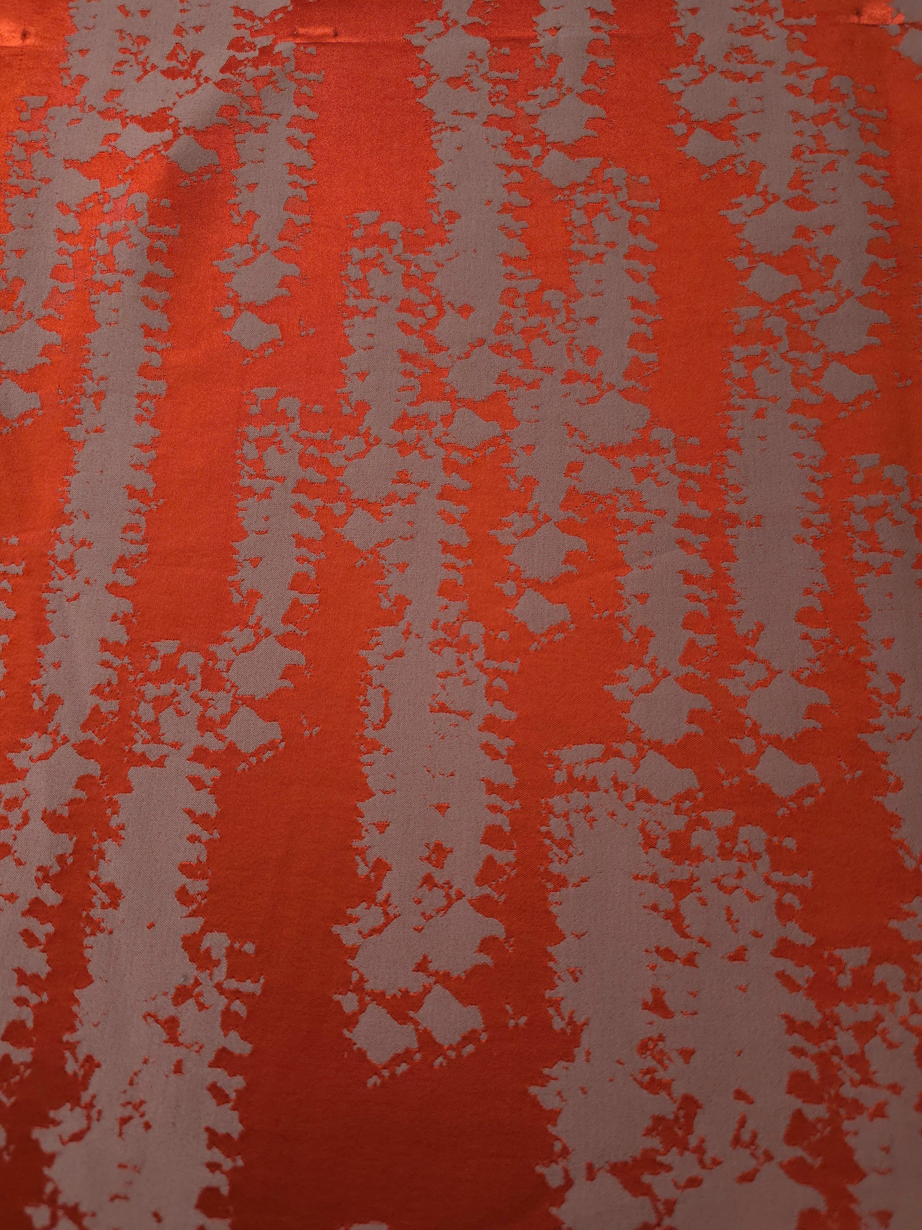 A wider section of the burnt orange and grey-mauve animal print satin, shown to judge the pattern at scale