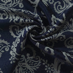 Navy baroque satin draped to catch the light, the cool grey scroll pattern visible across the fold