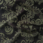Deep brown satin folded over, the sage-green baroque scrollwork standing out boldly against the dark base