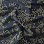 Navy satin folded over, the olive-khaki baroque scrollwork standing out warmly against the deep blue base