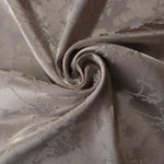 Taupe floral satin draped to show its fluid movement, the tonal motif visible mainly through sheen