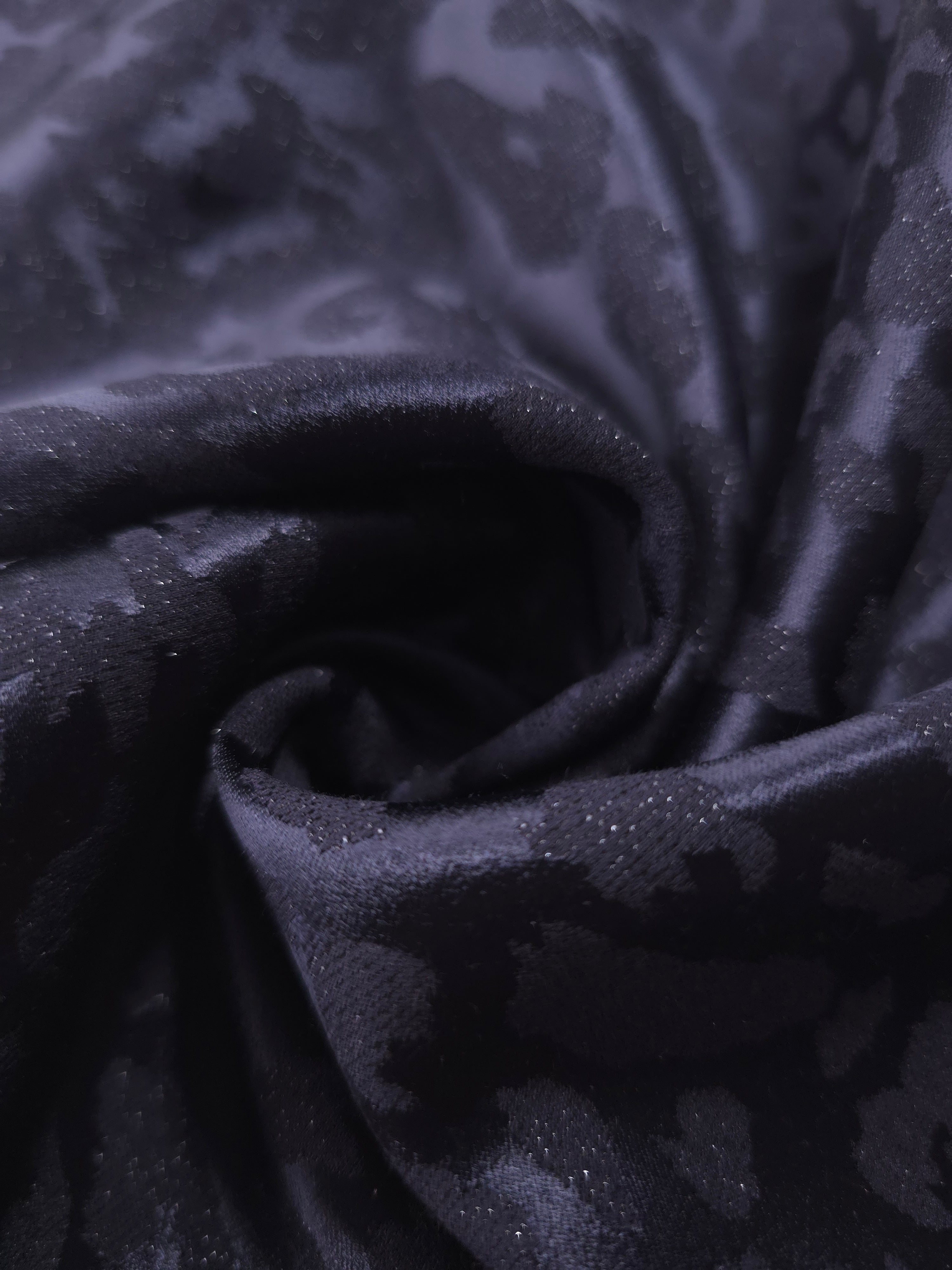 Close drape of leopard metallic jacquard showing raised motif and soft folds.