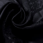 Close drape of alternate metallic wave jacquard showing raised texture and folds.