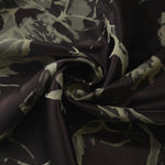 Black graphic line satin draped to catch the light, the irregular splatter motif visible across the fold