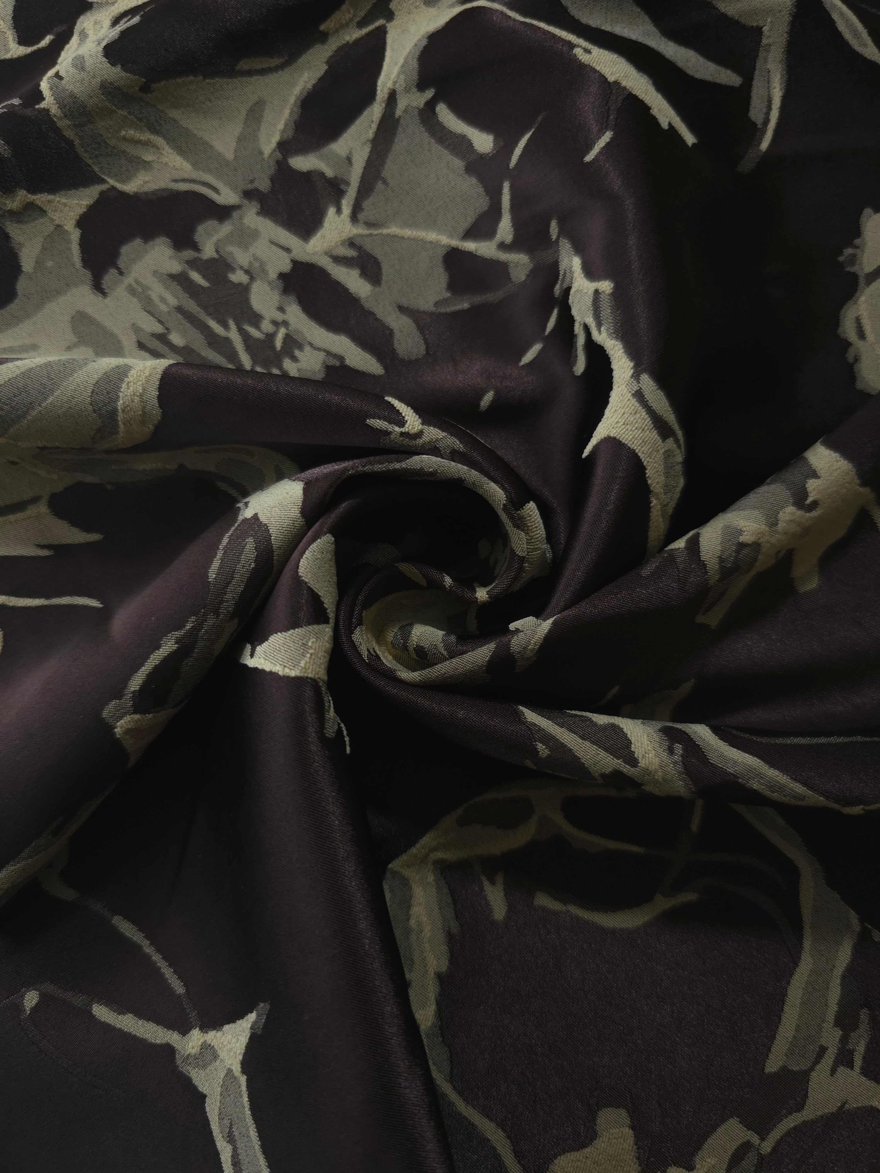 Black graphic line satin draped to catch the light, the irregular splatter motif visible across the fold