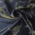 Navy-charcoal graphic line satin draped to show its glossy movement against the olive-tan splatter