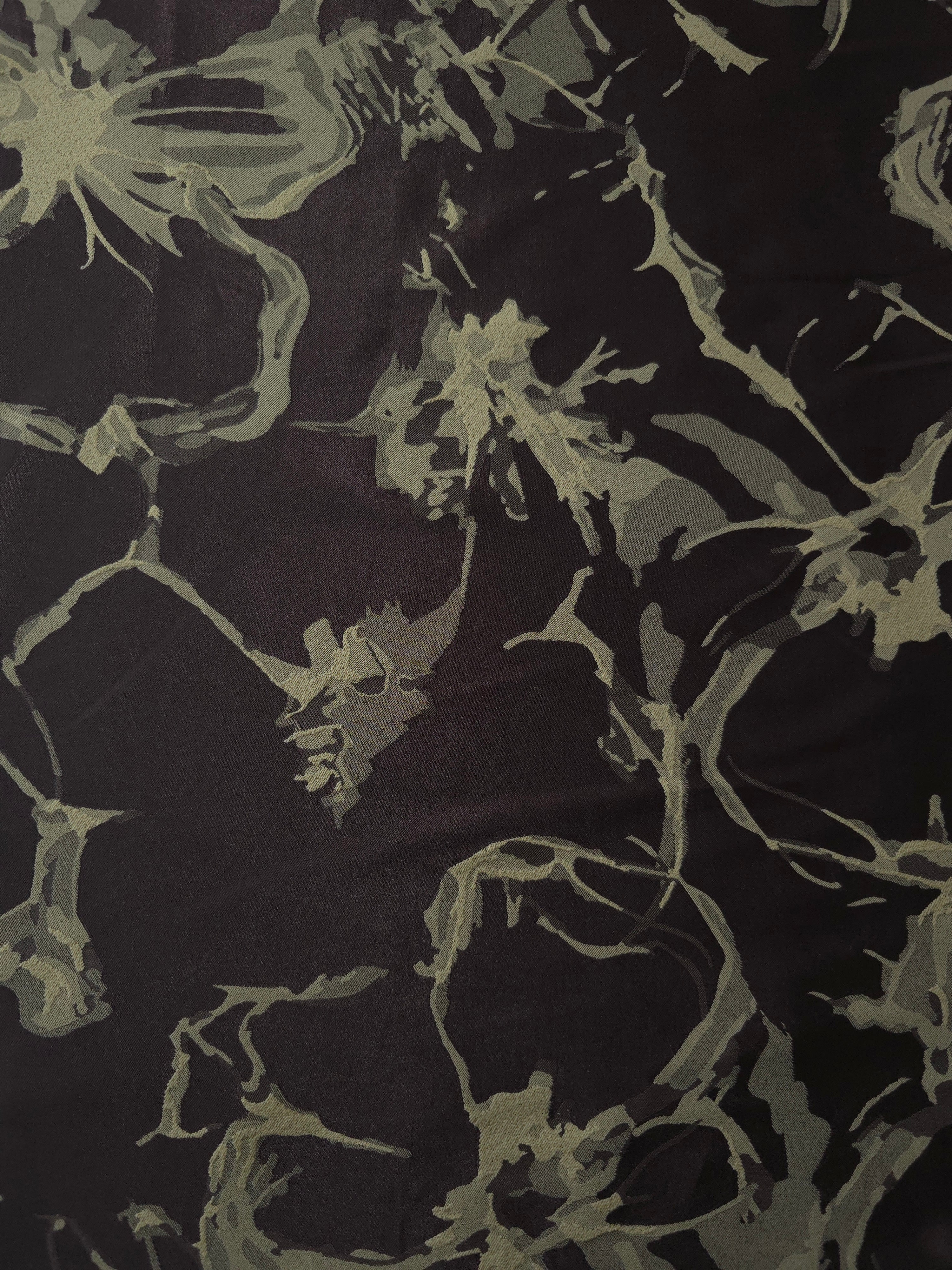 A wider cut of the black and sage-olive graphic line satin, shown to see the abstract pattern at scale