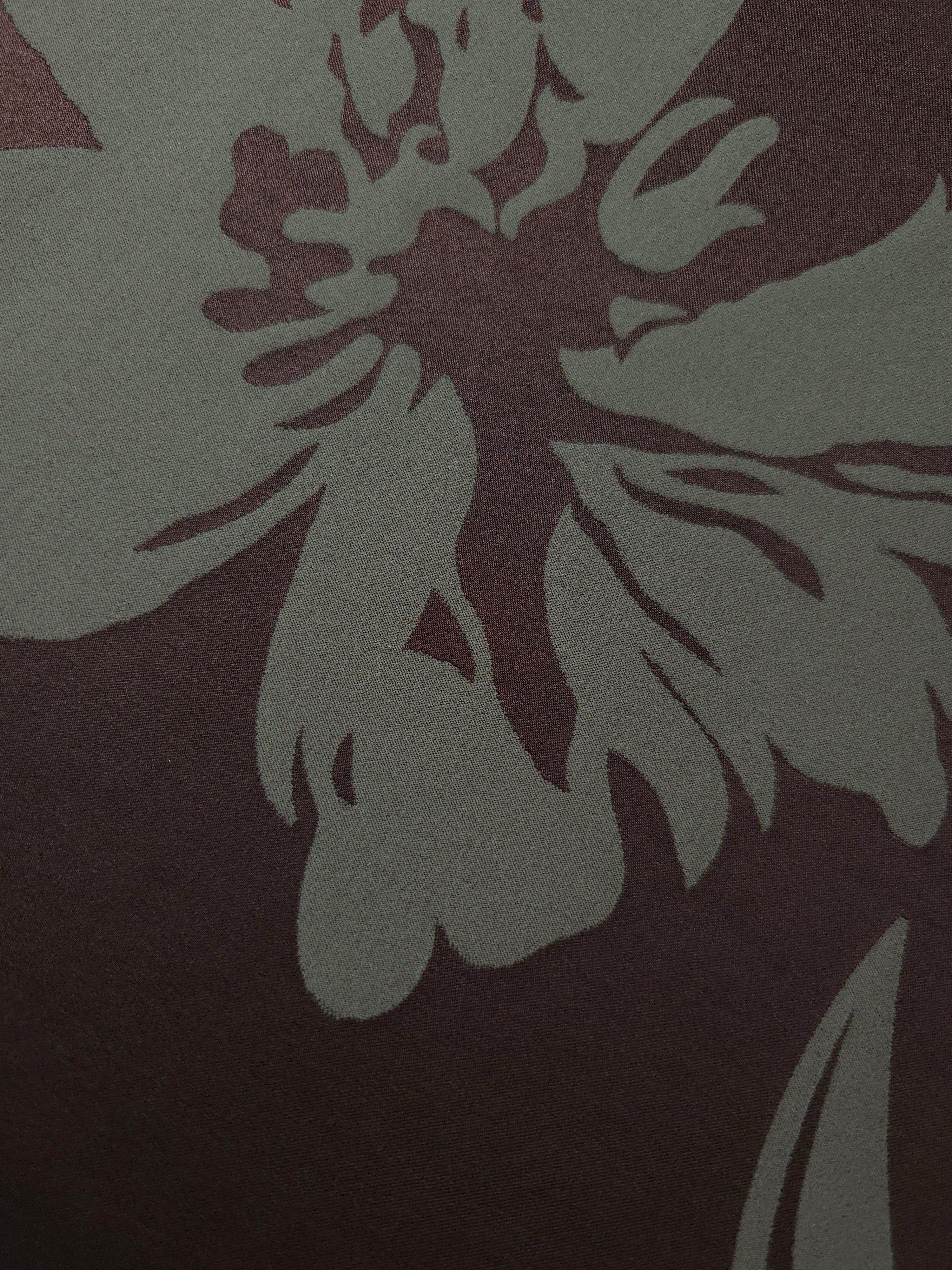 Close-up of the wine and sage hibiscus flower colorway, a large-scale bloom rather than a repeating small motif