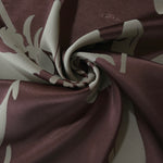 Wine hibiscus flower satin draped to catch the light, the bold petal shape visible across the fold