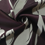 Eggplant hibiscus flower satin draped to show its glossy movement against the sage petal detail