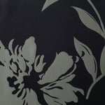 A wider view of the black and sage hibiscus satin laid flat, showing the full bloom repeat
