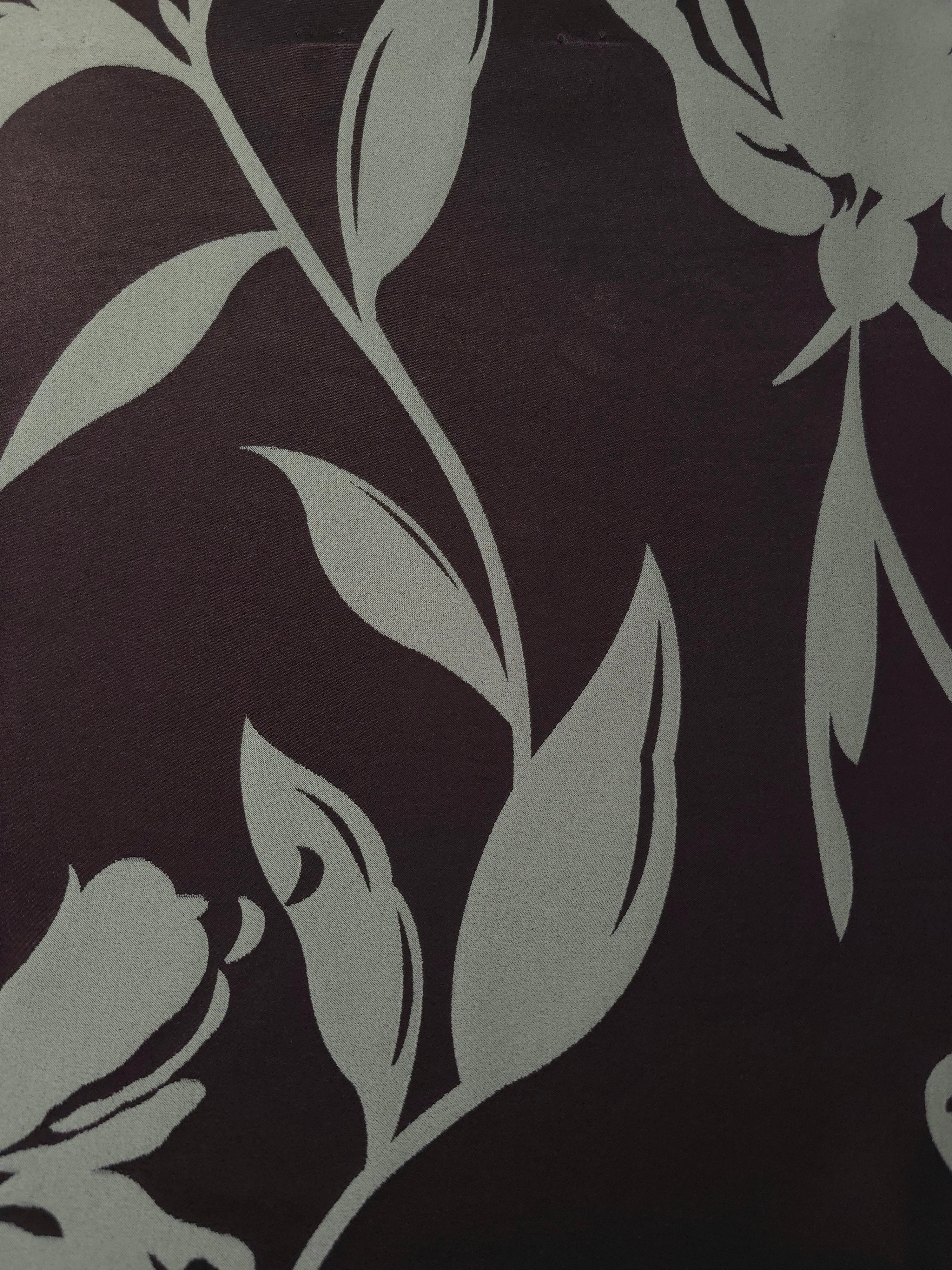 A wider section of the eggplant and sage hibiscus satin, shown to judge the bold floral pattern at scale