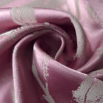 A tight fold in the mauve-plum satin, the leaf branches bending with the crease of the fabric