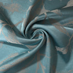 Teal leaf-pattern satin draped to show its glossy movement against the taupe branch motif