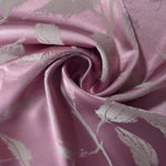 Mauve-plum leaf-pattern satin draped to catch the light, the grey branch motif visible across the fold