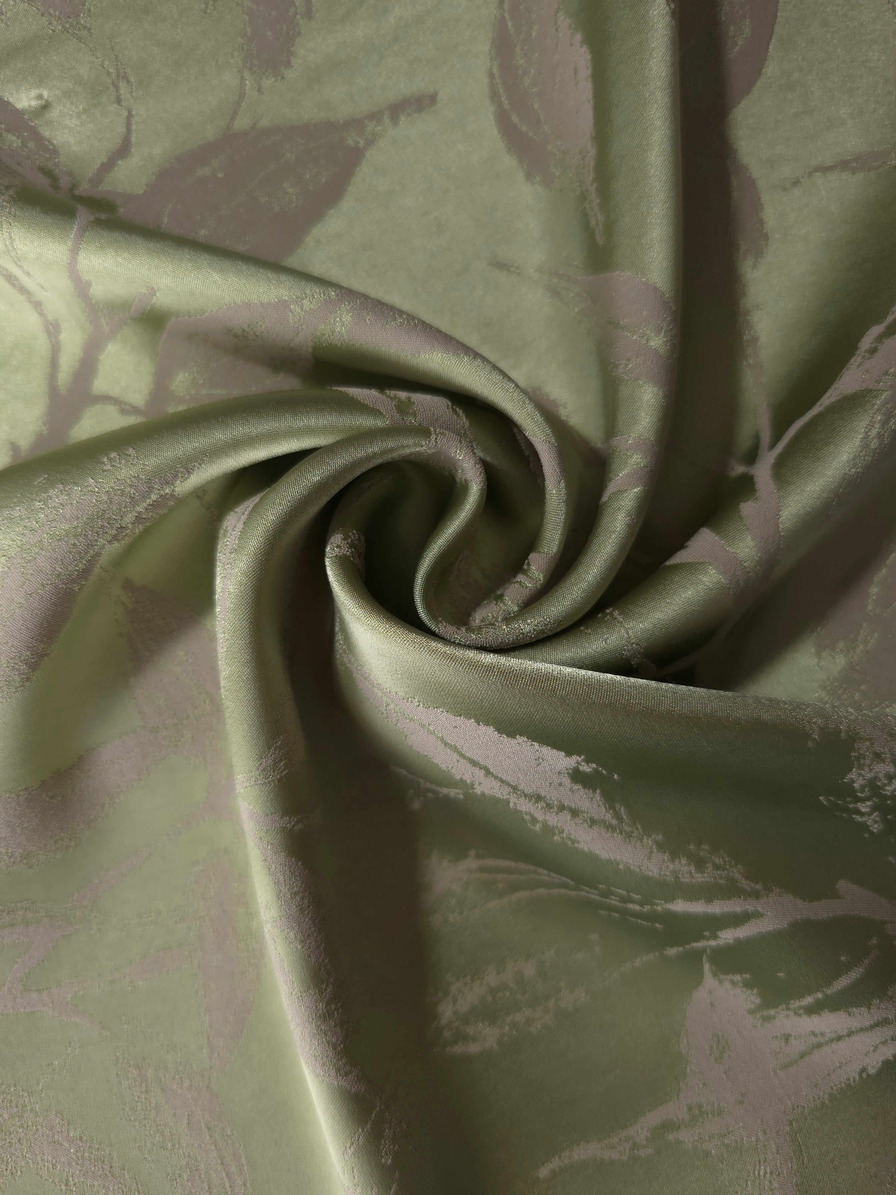 Olive green Lassi satin draped loosely, suited to buyers wanting an earthy, low-contrast leaf print