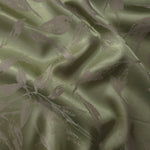 Olive green satin folded softly, the leaf branches reading as a deeper tonal shadow across the surface