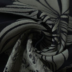 A soft crease in the black satin, the lily outline breaking across the fold