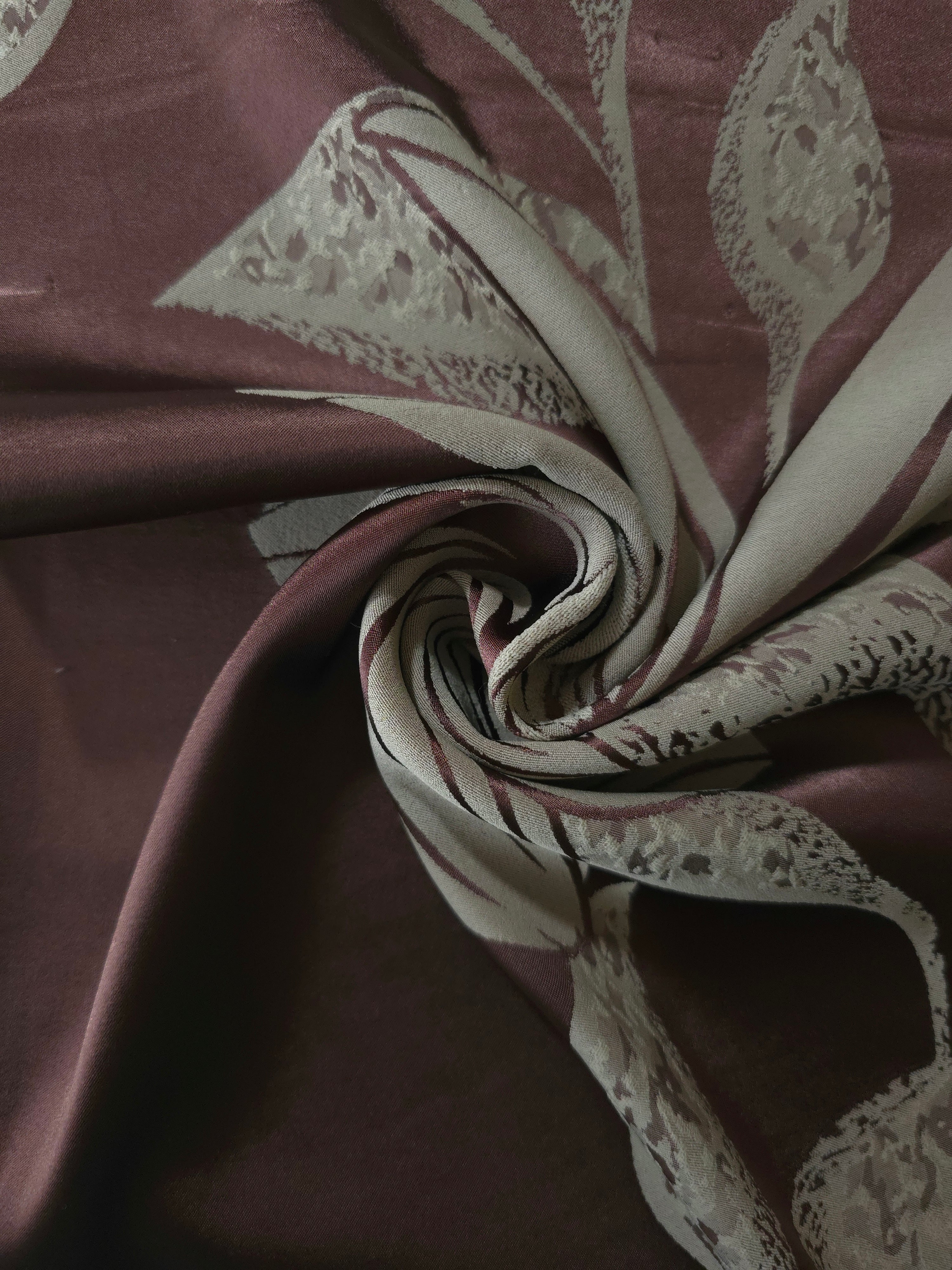 Maroon lily flower satin draped to show its glossy movement against the sage petal detail
