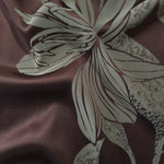 Maroon satin folded over, the sage-grey lily petals showing a textured speckled fill within the outline