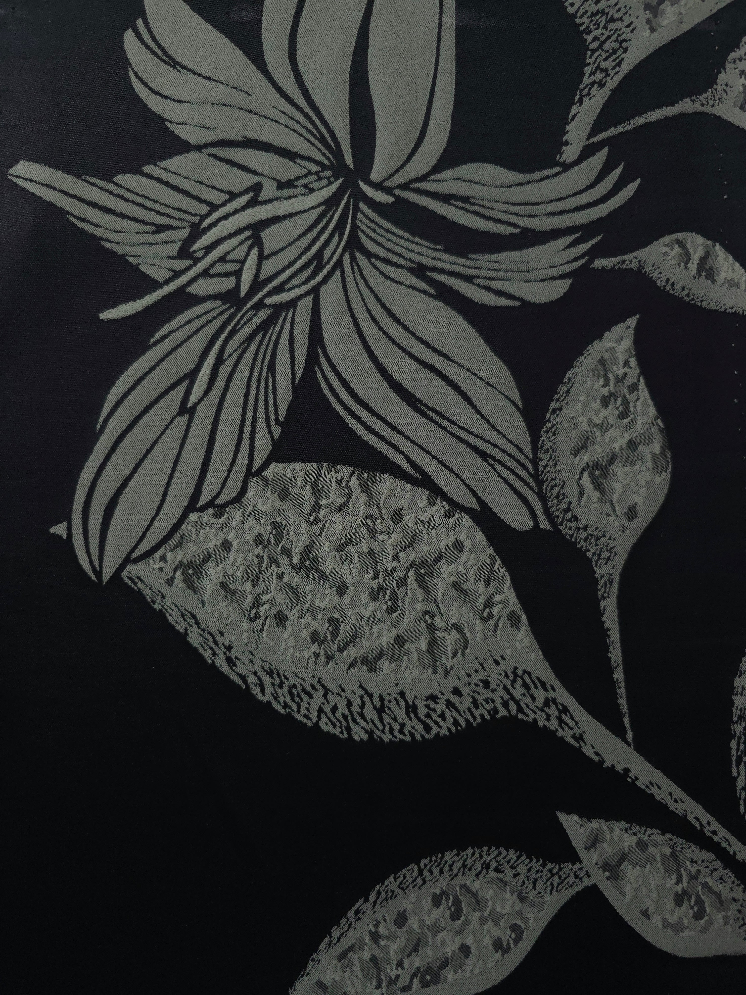 A wider view of the black and sage lily flower satin laid flat, showing the full line-art repeat