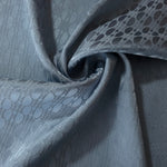 Slate blue lattice satin draped to show its glossy movement against the repeating oval texture