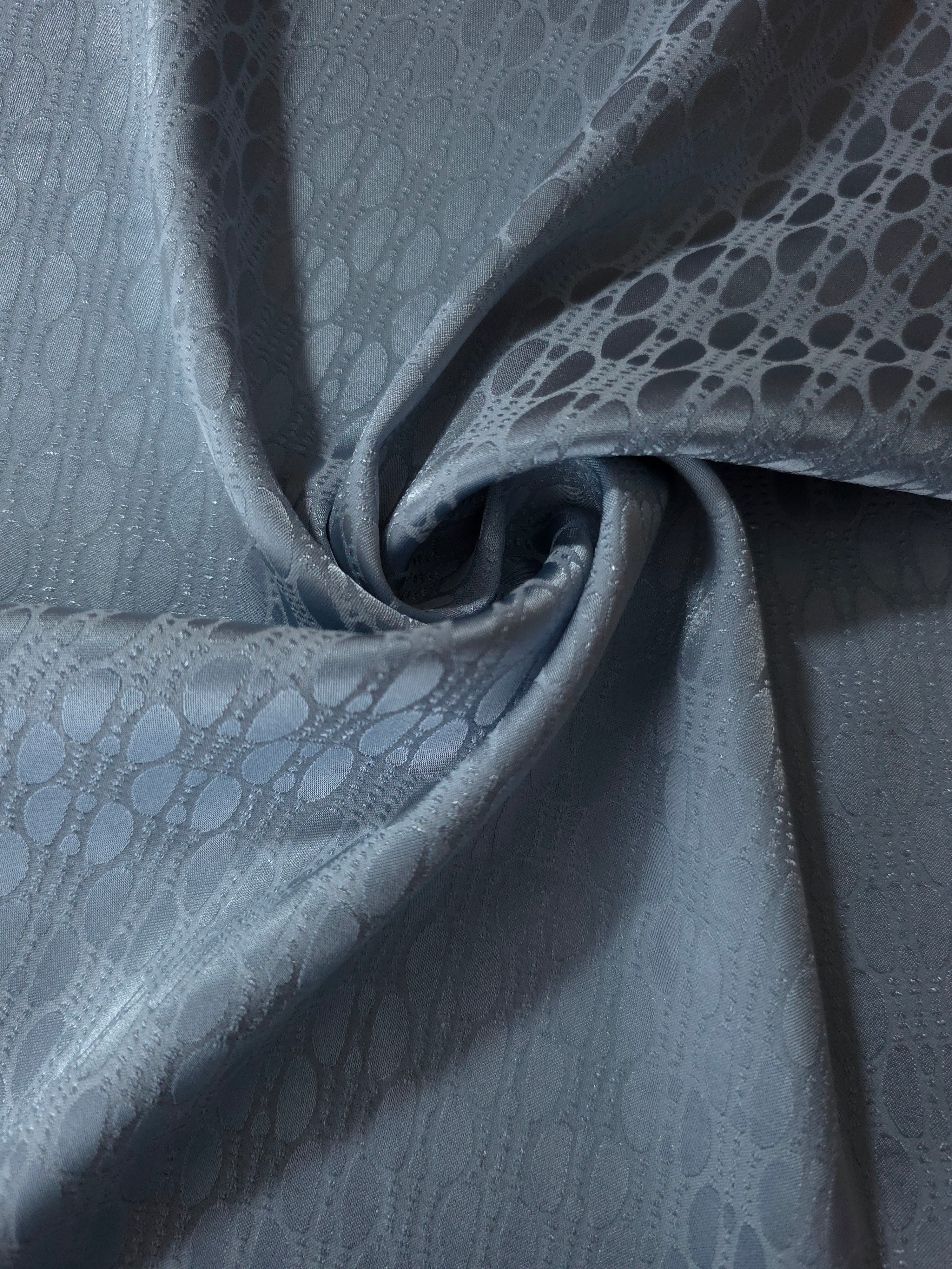 Slate blue lattice satin draped to show its glossy movement against the repeating oval texture