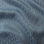 Slate blue satin folded over, the repeating oval lattice pattern reading as a structured geometric texture